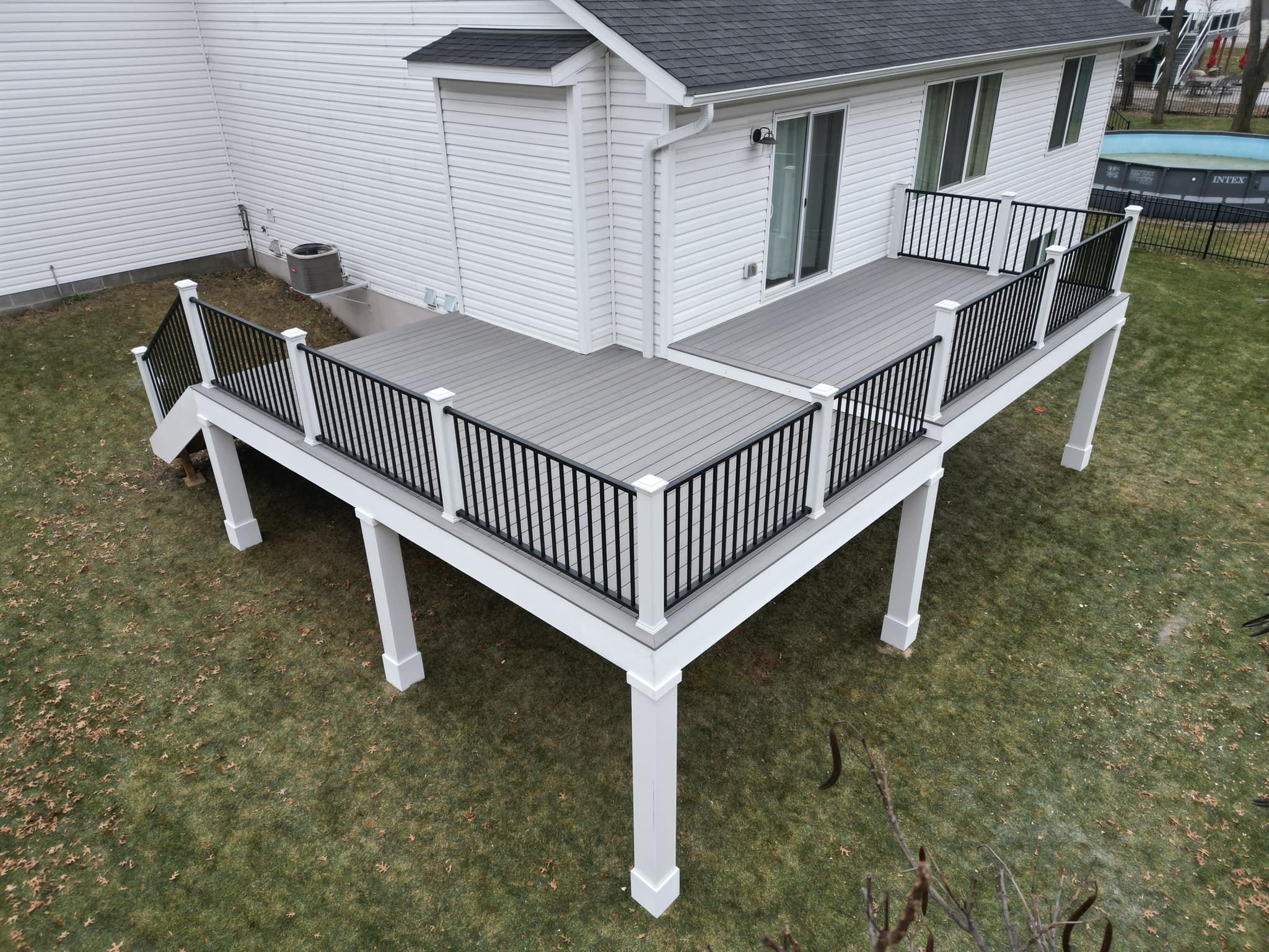 Grey deck with black and white railing. 