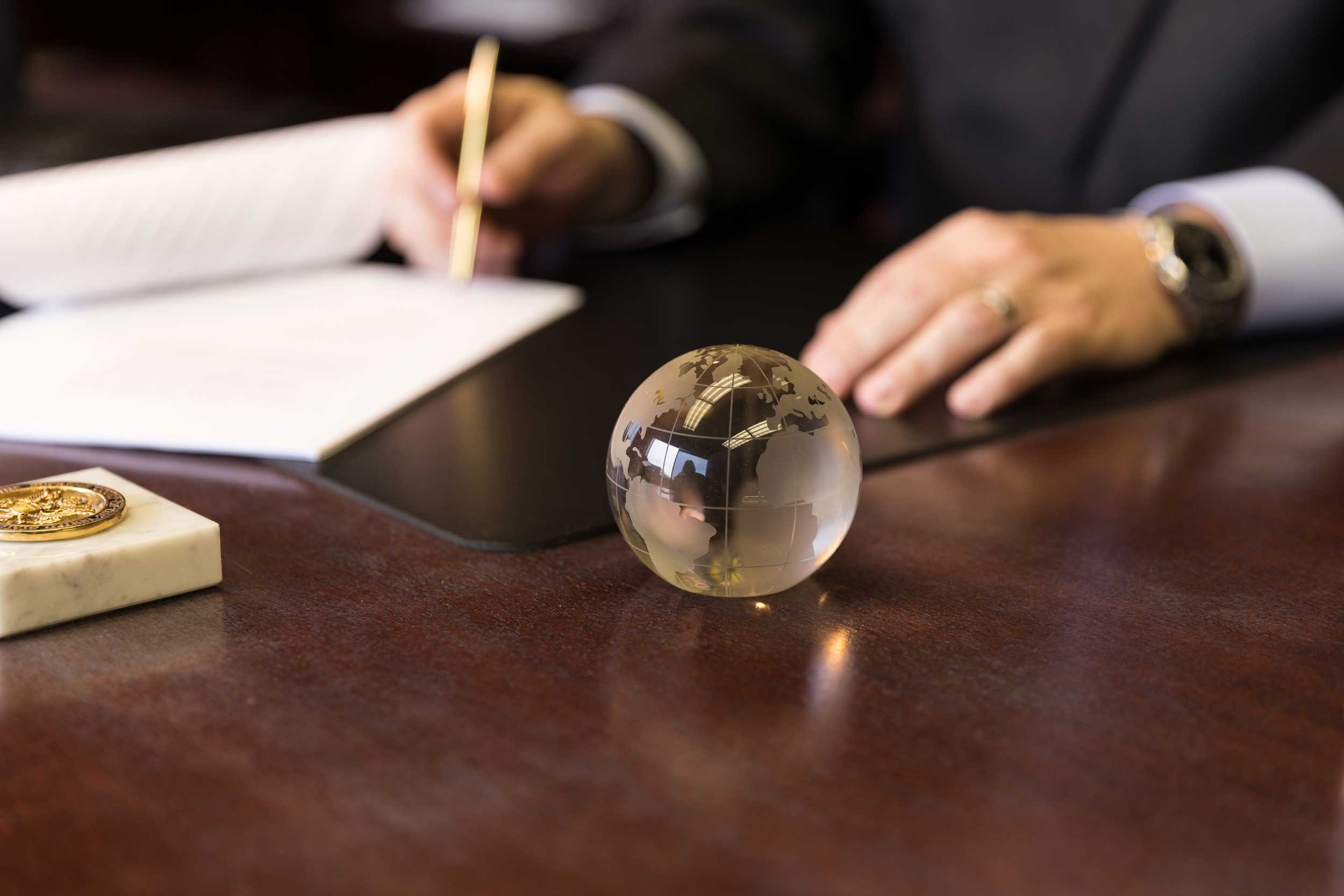 attorney-desk-glass-globe-signing-papers