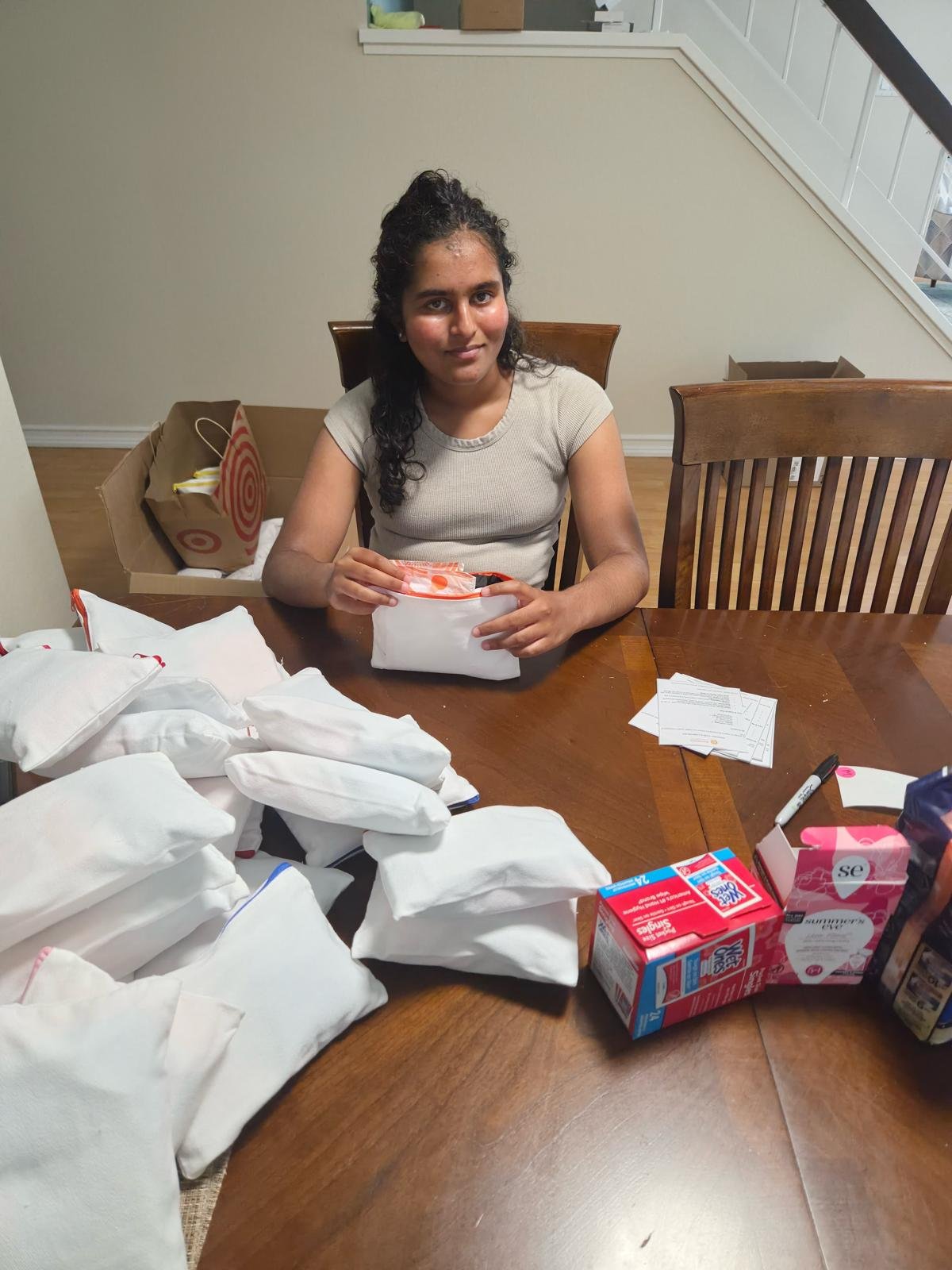 Youth volunteer packing first aid kits for girls. Also delivered to shelters.