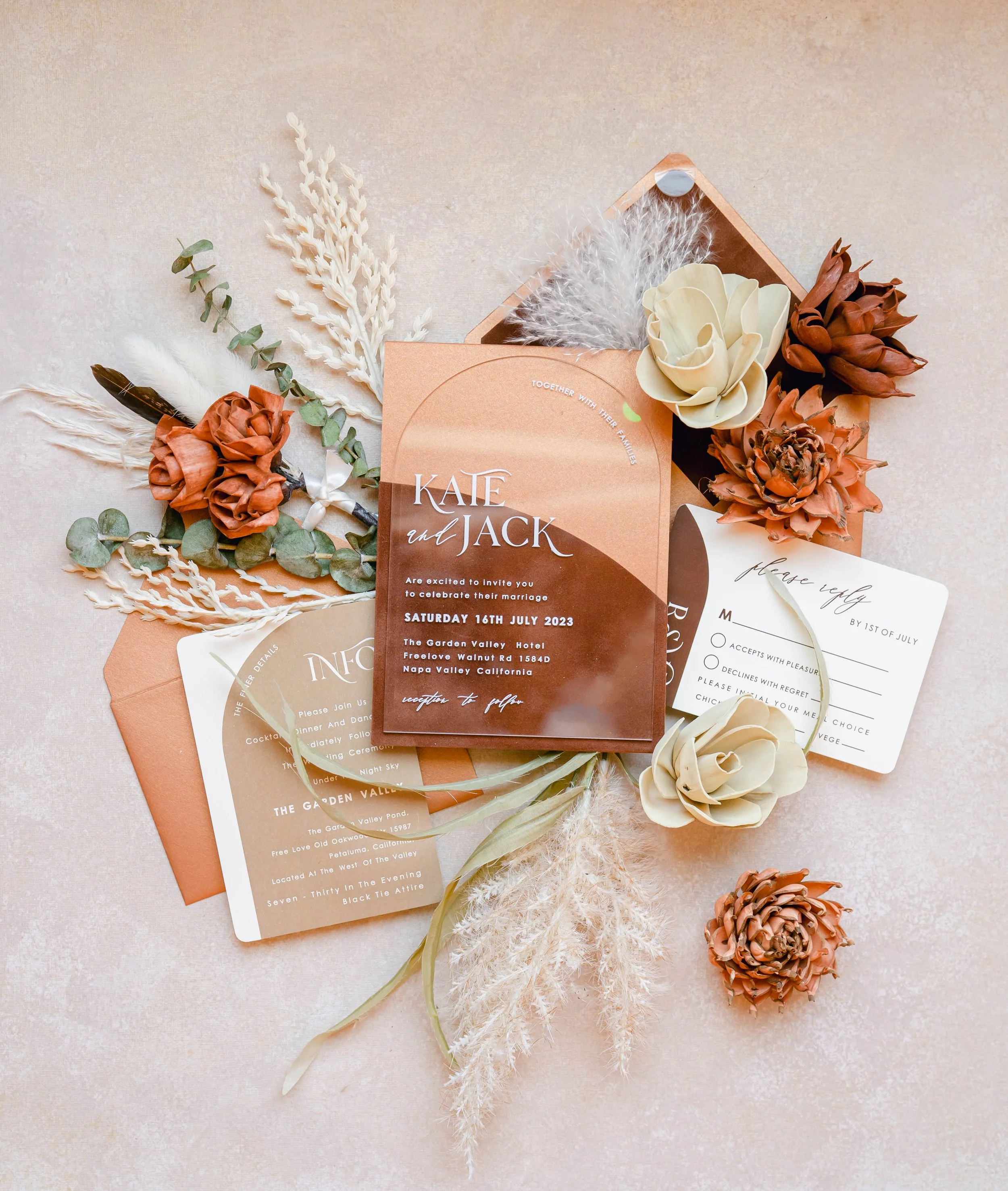 A newlywed couple smiling and clinking champagne glasses at their wedding reception, sitting close together.