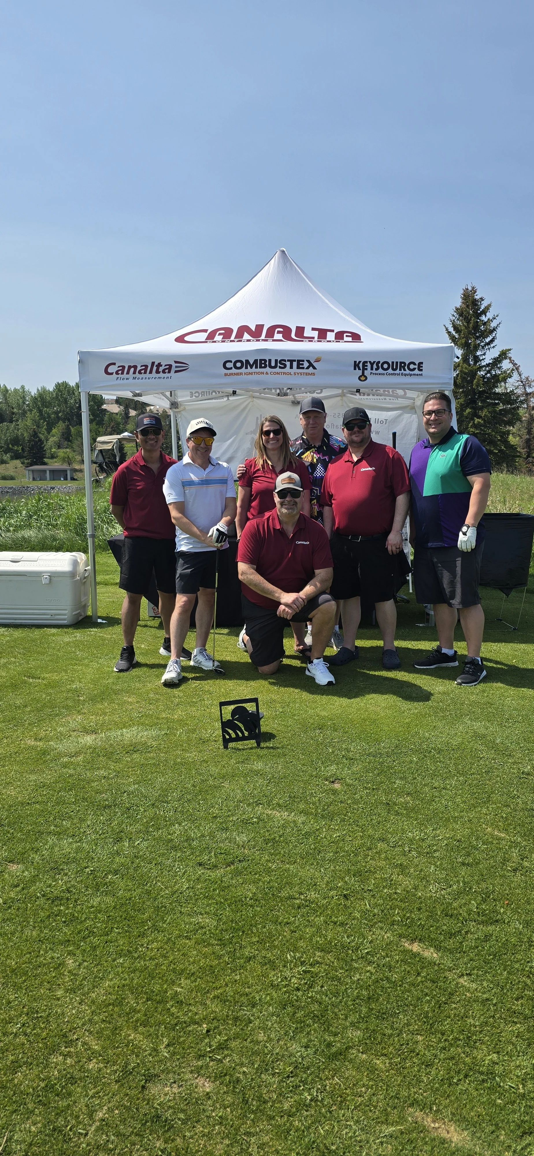 A group of people posing for a photo during a non profit golf tournament planned by Neesa and Co Events.