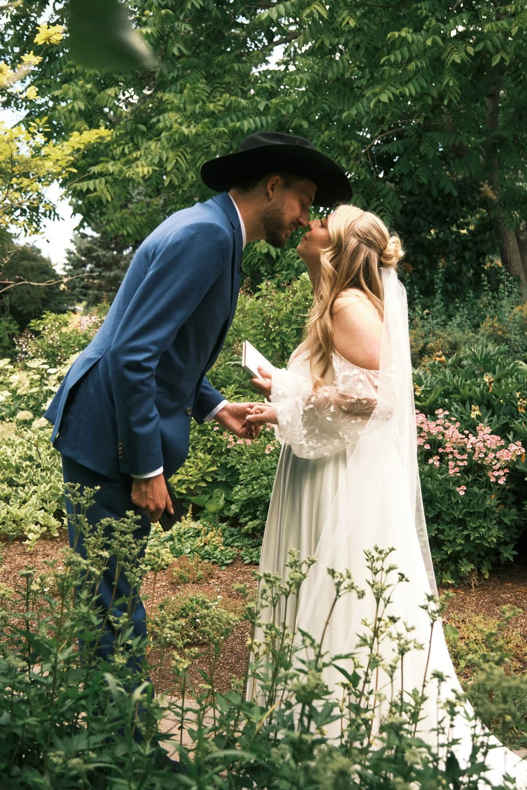 A wedding couple standing outside in a garden kissing during a wedding coordinated by Neesa and Co Events.