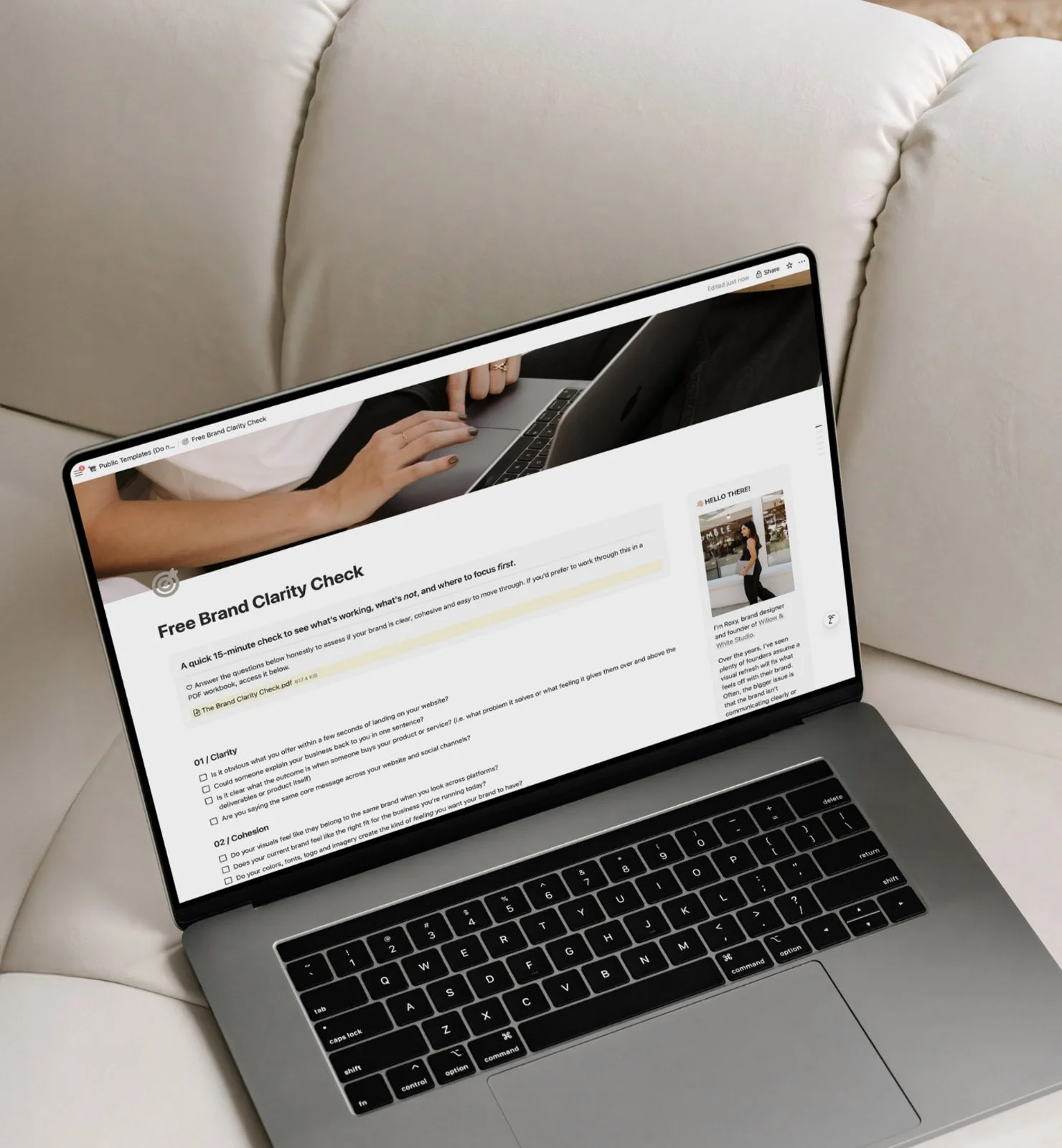 Laptop on a white couch displaying a webpage titled 'Free Brand Clarity Check' with questions and checkboxes.