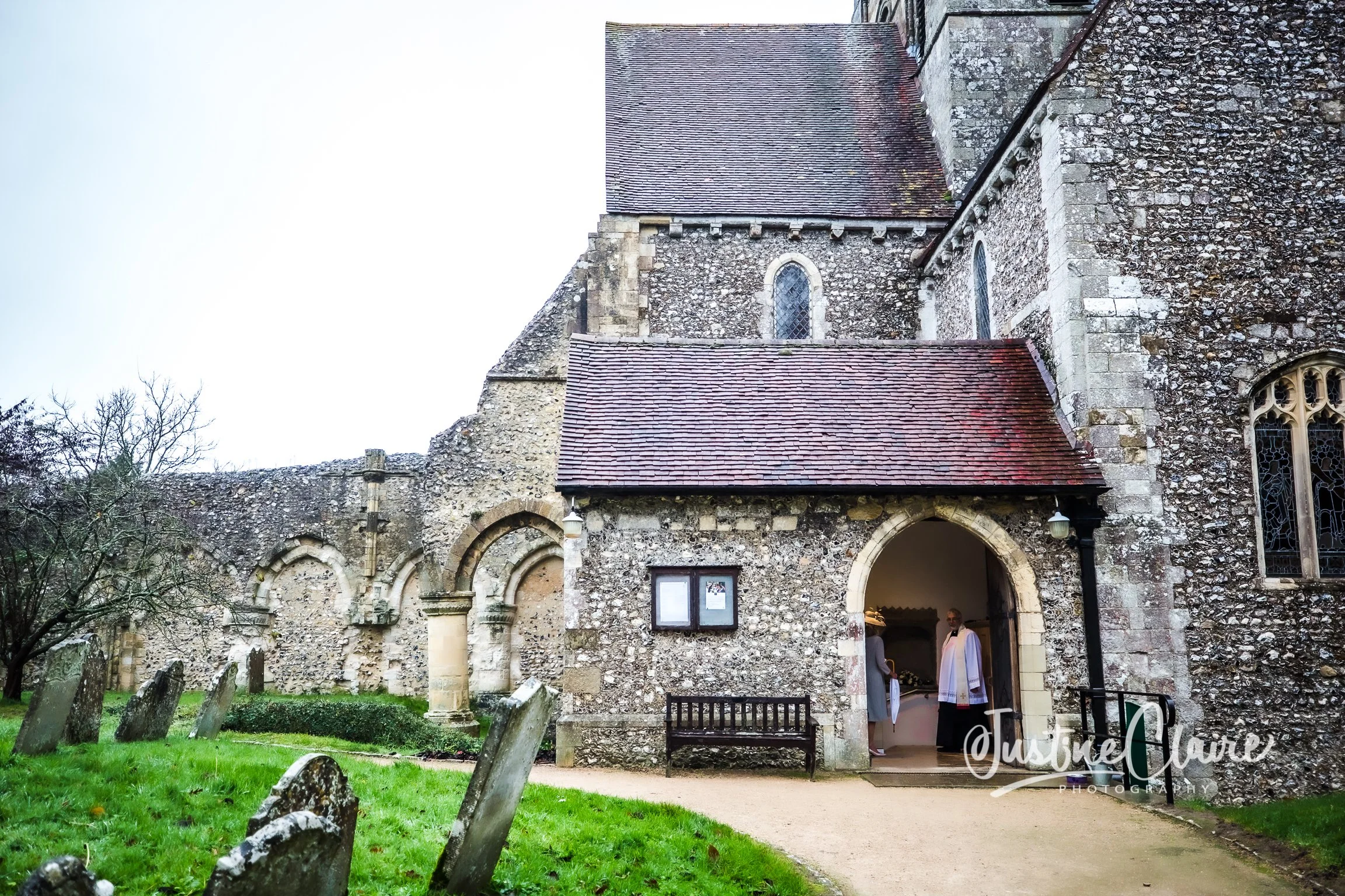 Stone church entrance with priests preparing for a religious service