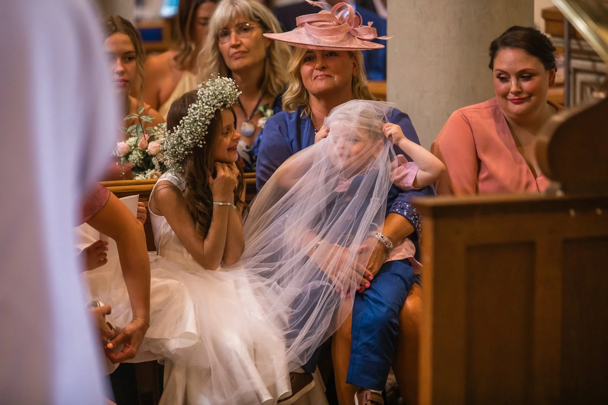 child pulling veil over his head cute
