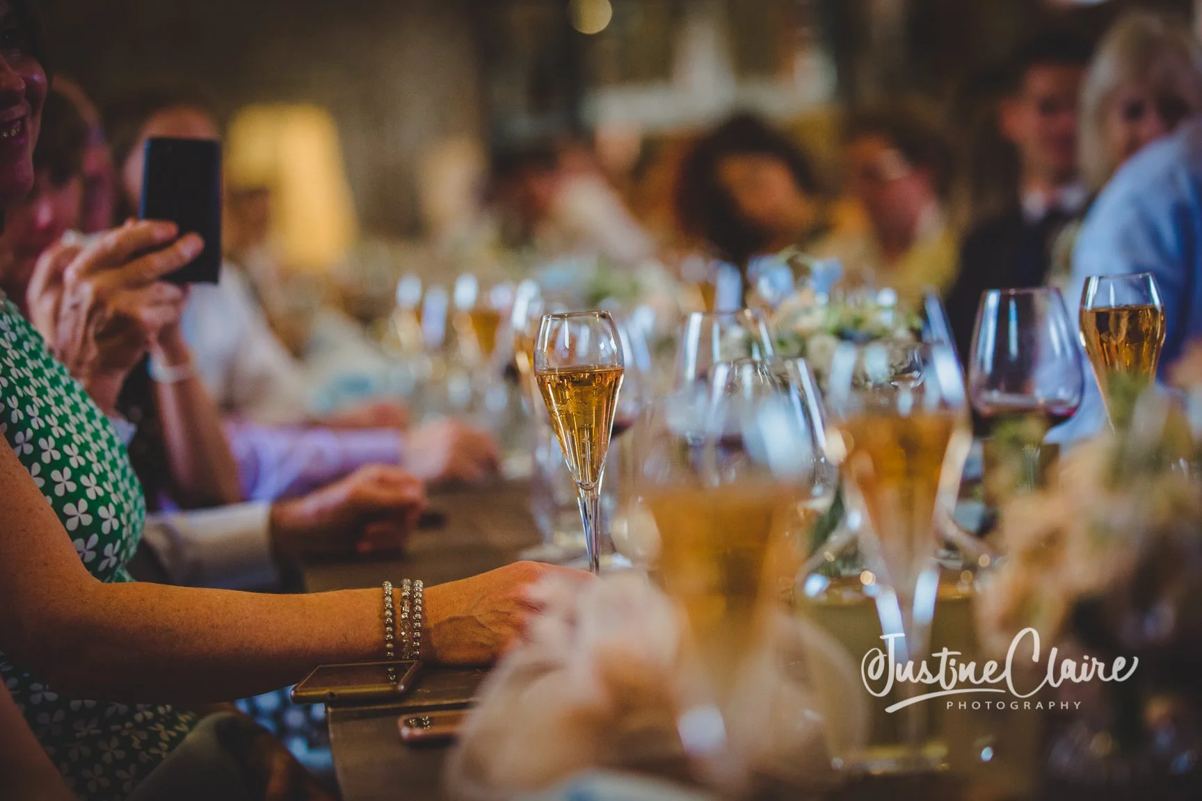 People gathered at a dinner table with glasses of champagne and wine during an event or celebration.
