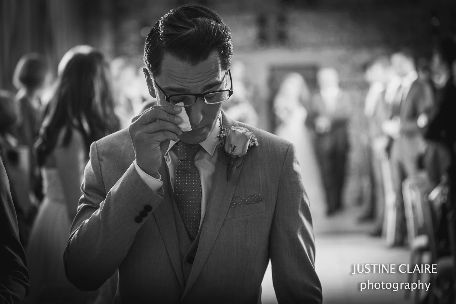 Groom crying and shedding tears as his bride enters the room in west sussex wedding photography