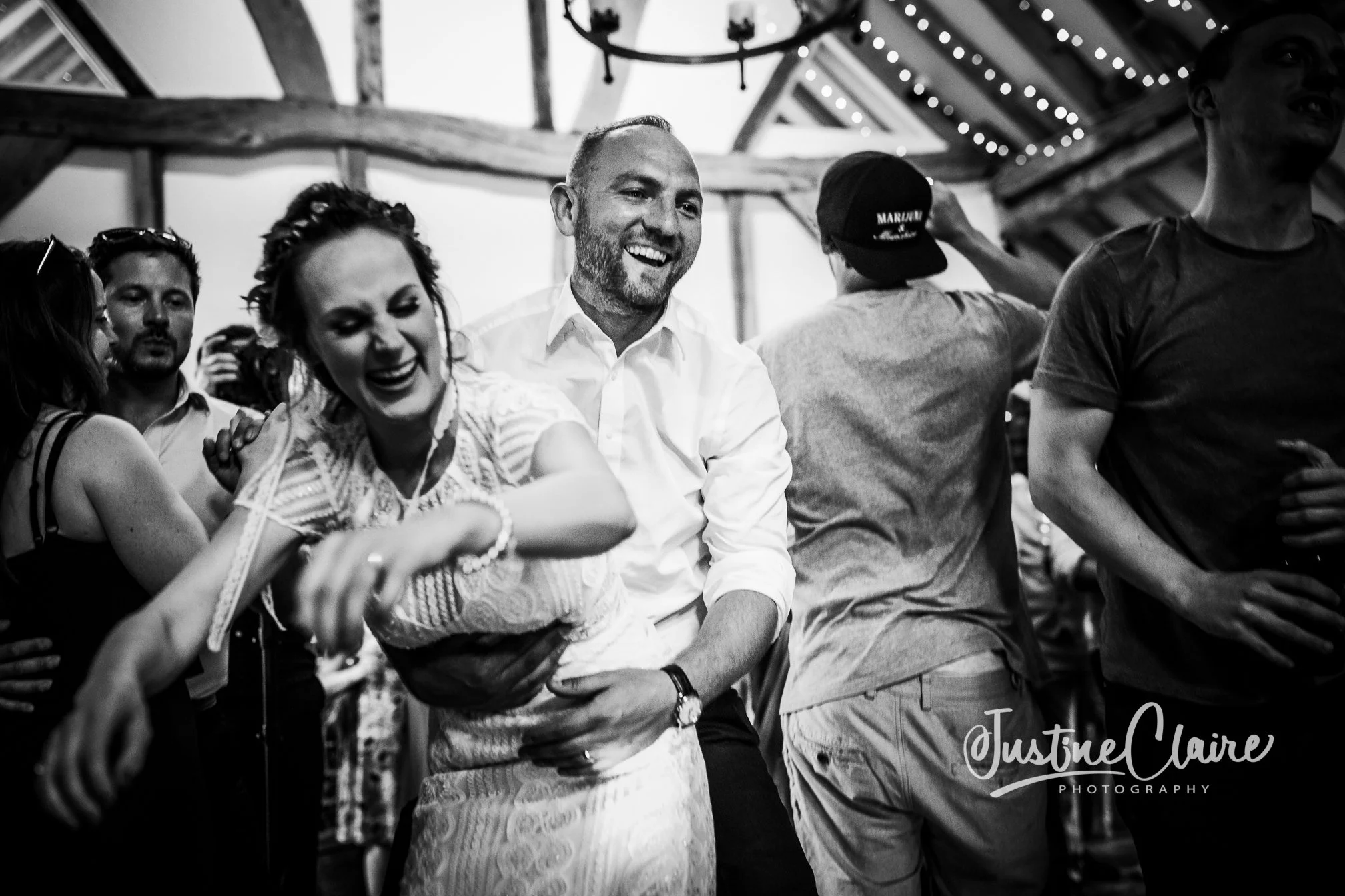 People dancing and celebrating indoors, smiling and enjoying themselves at a social gathering.