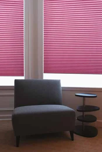 Pink pleated blinds with chair in the front
