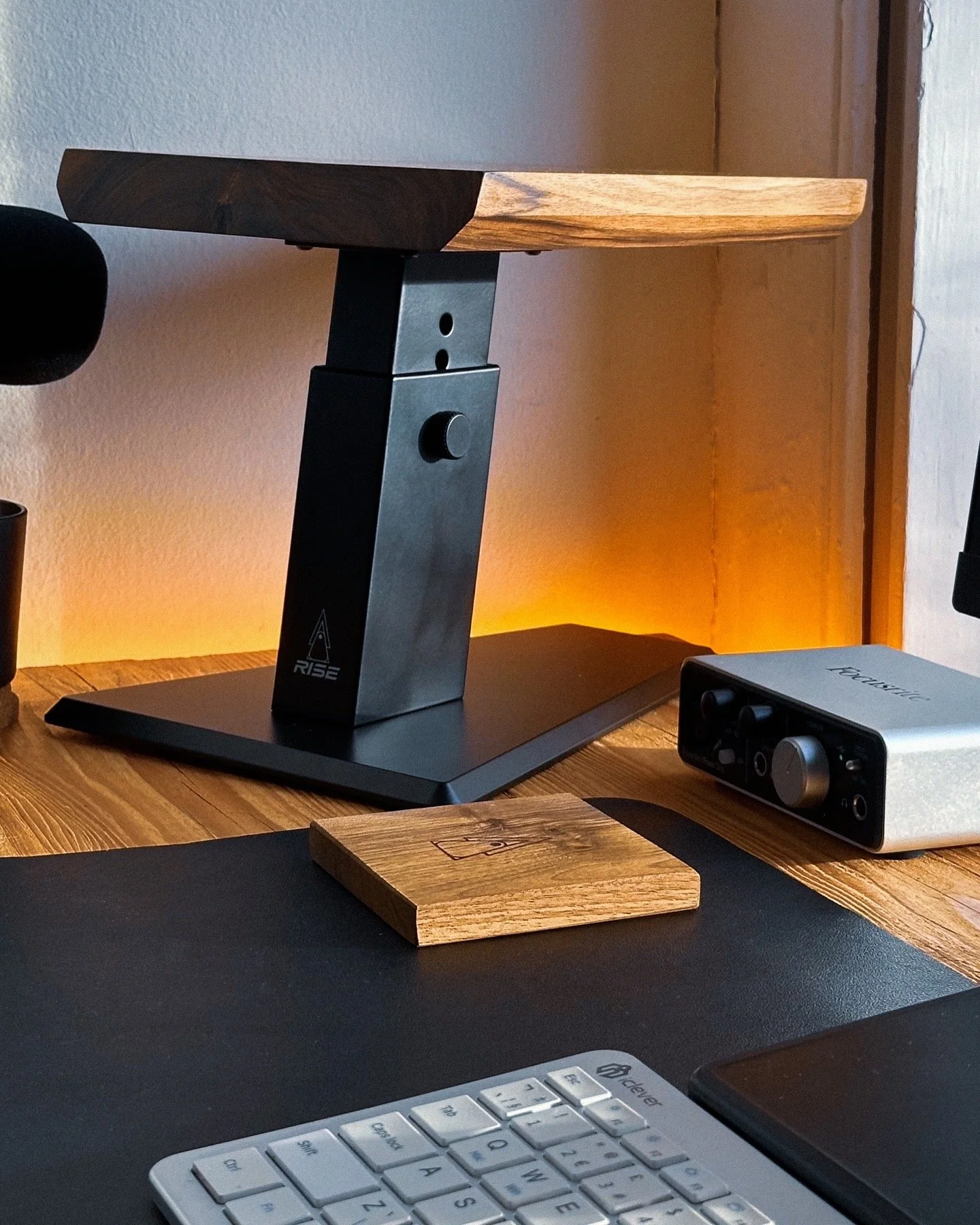 Rise Audio walnut coaster on a studio desk below a monitor stand