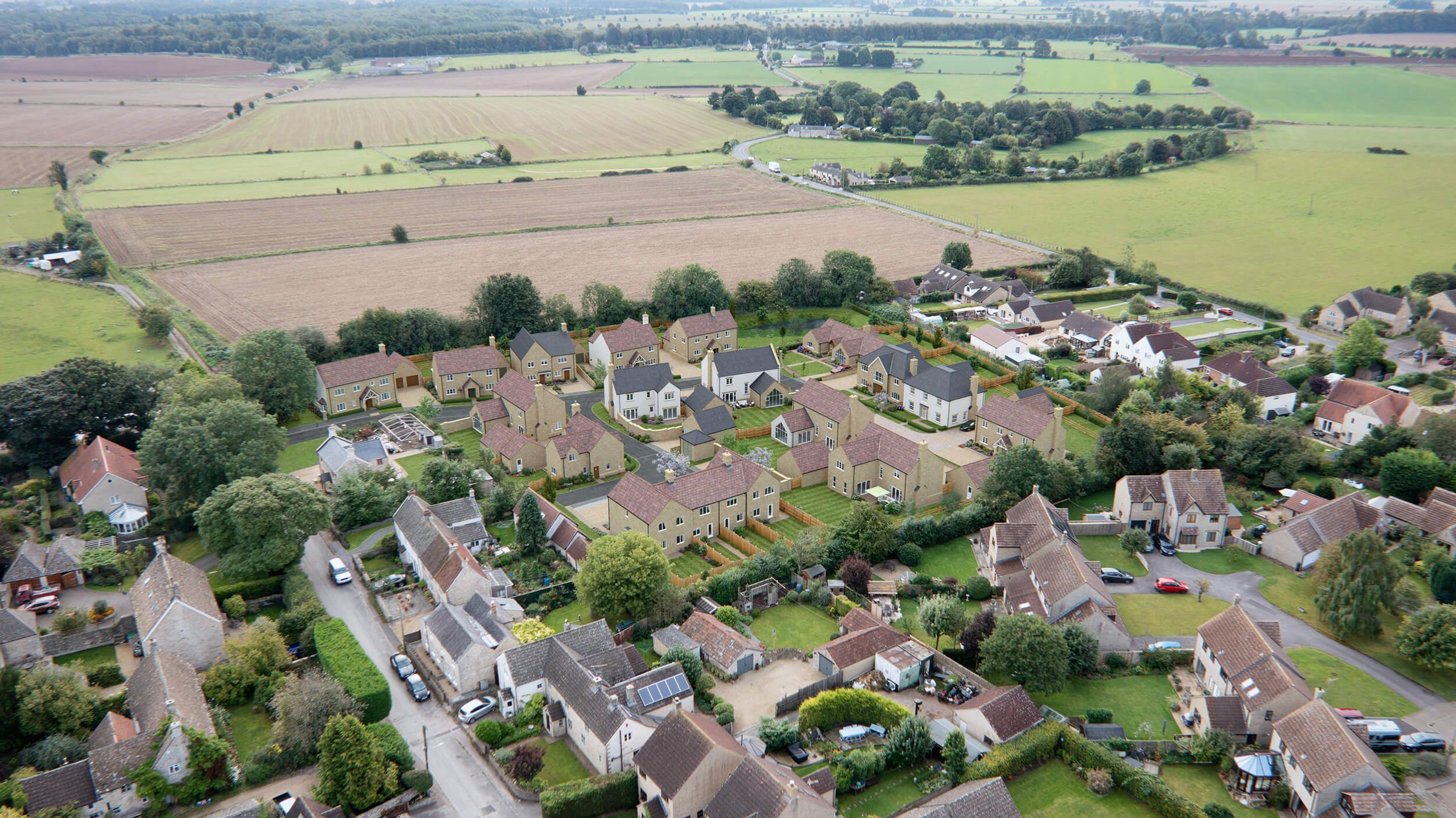 Residential property CGI aerial photomontage showing a new housing development blended into a real aerial landscape for off-plan marketing.