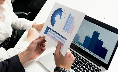 Comprehensive Evaluation at Diagnostic Learning - Person holding printed business chart with bar and line graphs