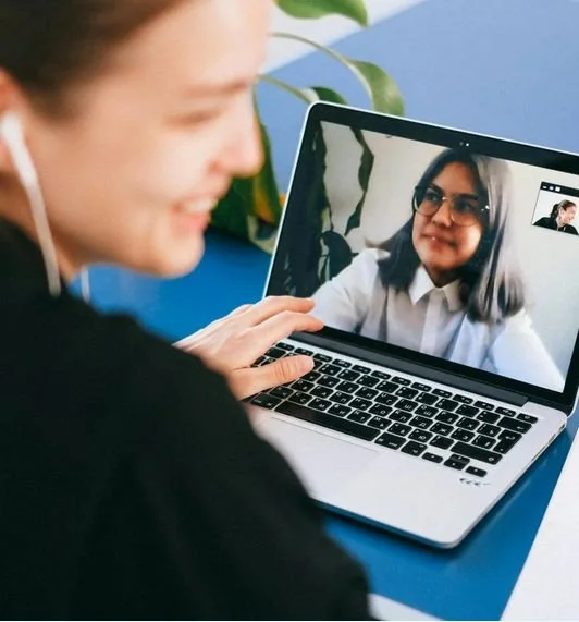 A woman smiling during a video call with a woman wearing glasses on a laptop screen - featured on Is Learning a Challenge?