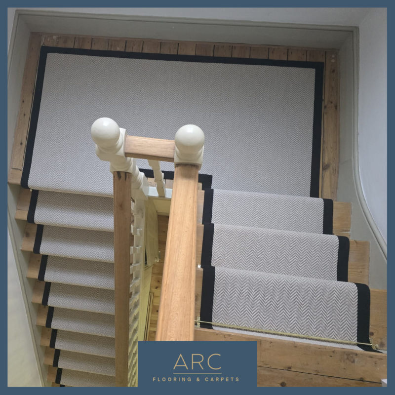 Landing and stairs herringbone carpet stair runner with binding tape and stair rods Catford.png