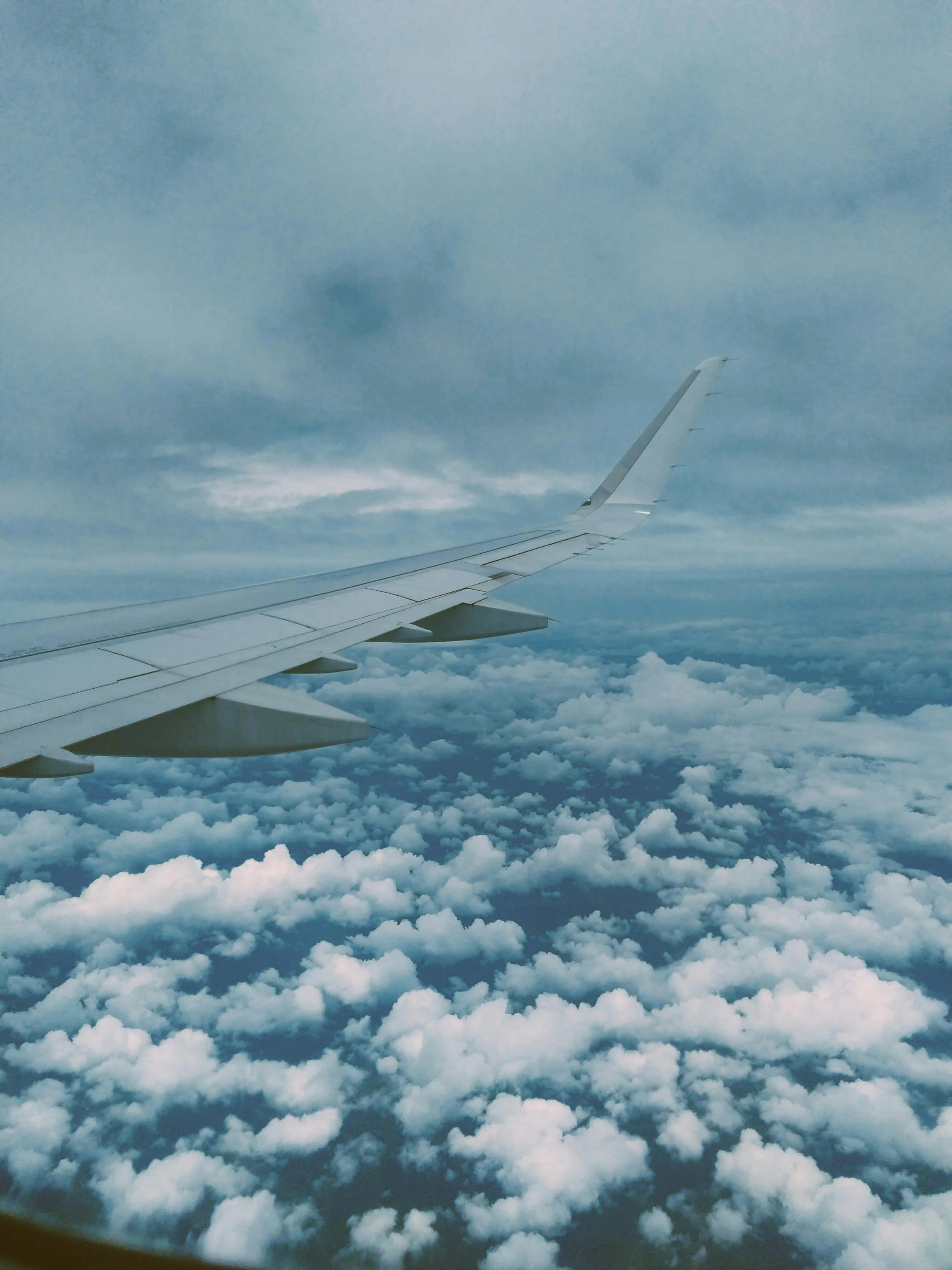 Image of plane wing above clouds.