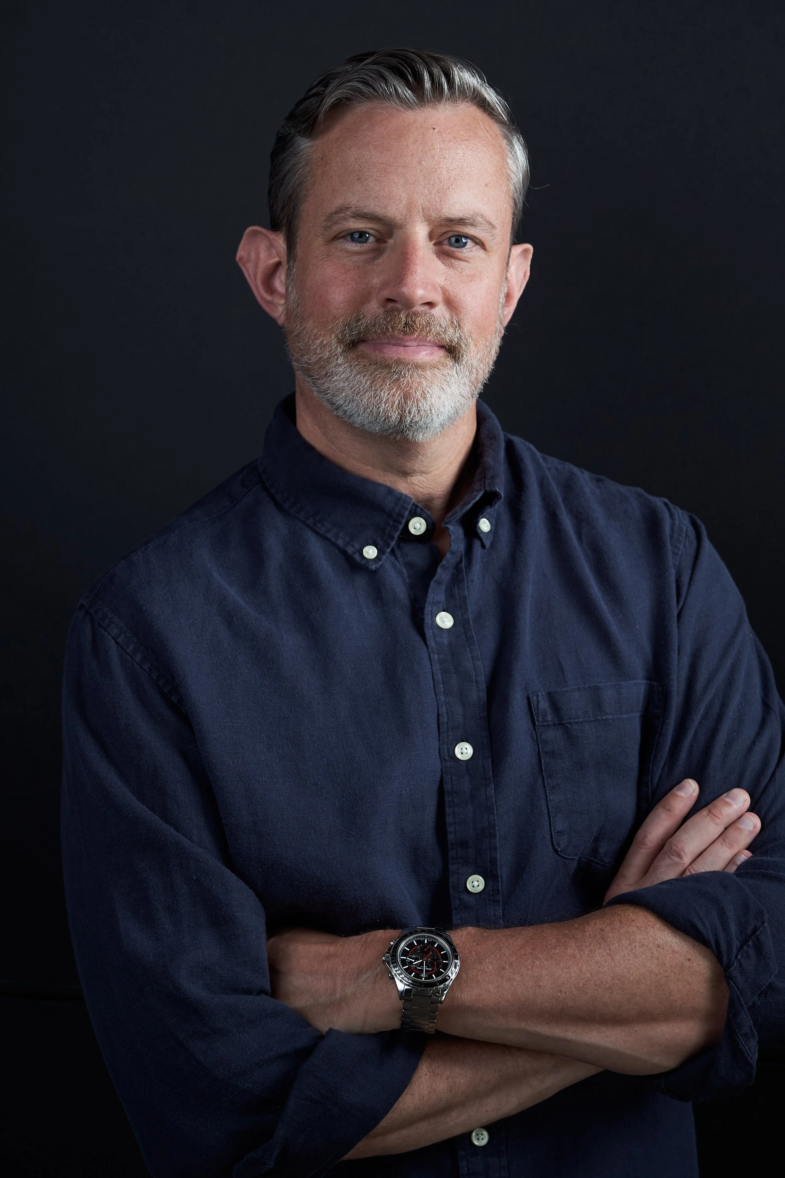Therapist C. Matthew Nichols, PHD smiling with a blue button up shirt on with warm and welcoming body language.