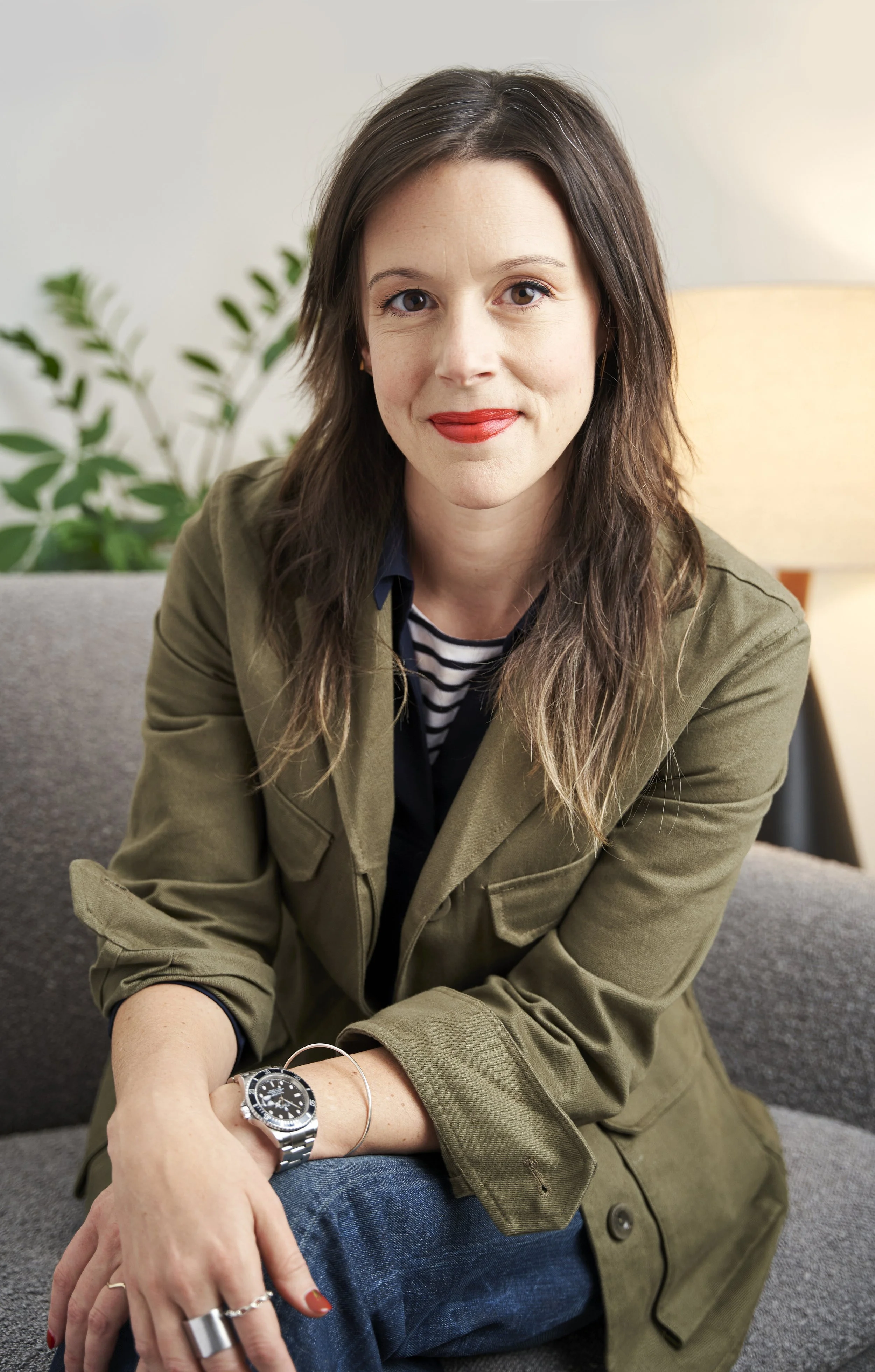 Therapist Ashleigh Ide, LMSW, sitting on a couch, smiling, giving a warm, welcoming appearance.
