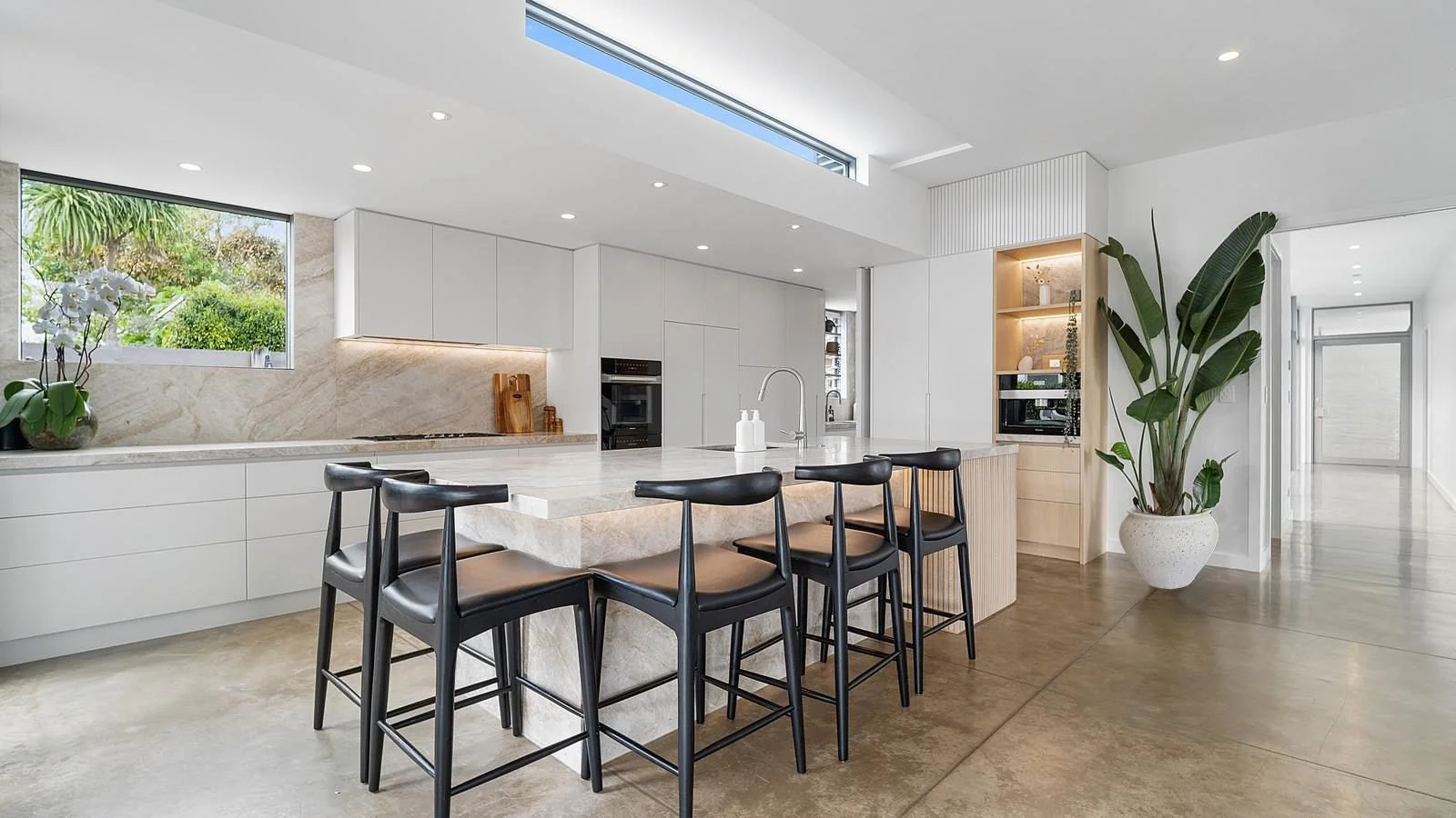 Kitchen renovation in Manly by Ze Build including stone benchtop and splashback, neutral colours with timber detailing with hidden scullery