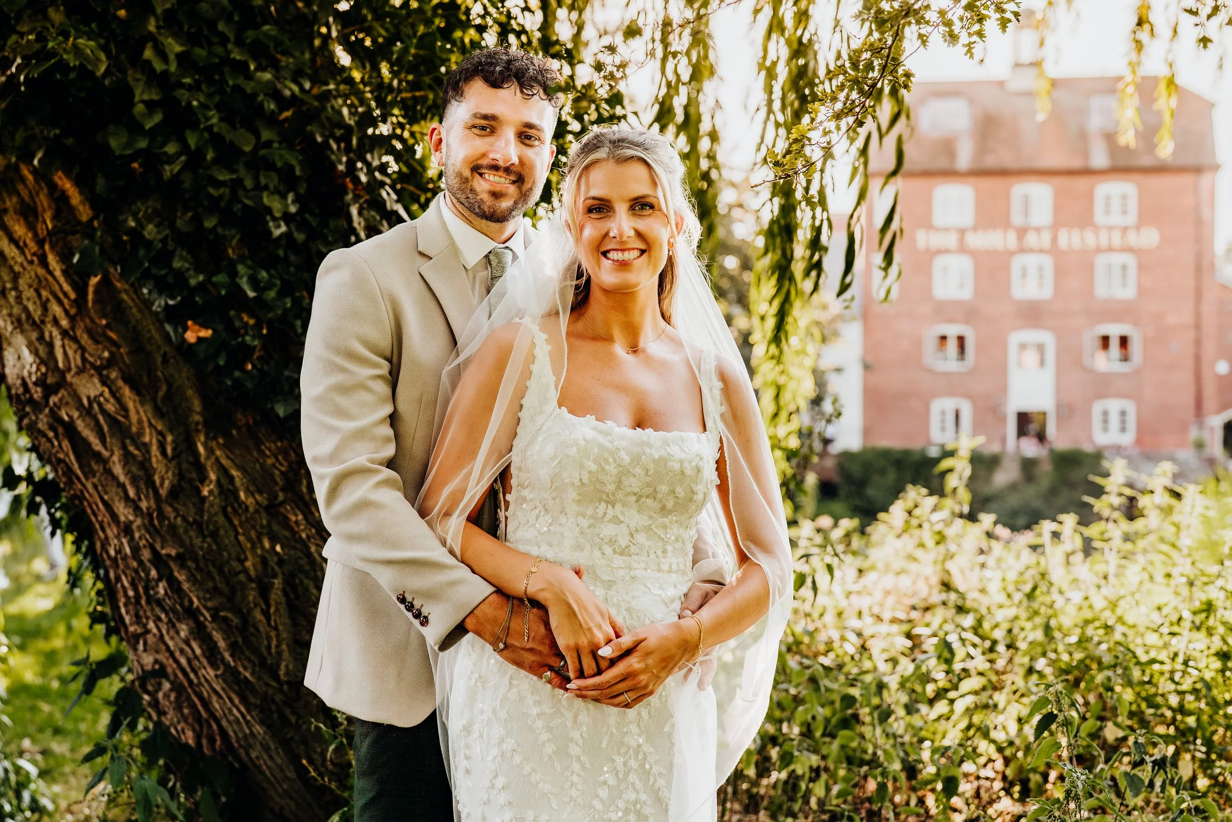 Bride and groom golden hour portrait with The Mill at Elstead building in the background, Surrey