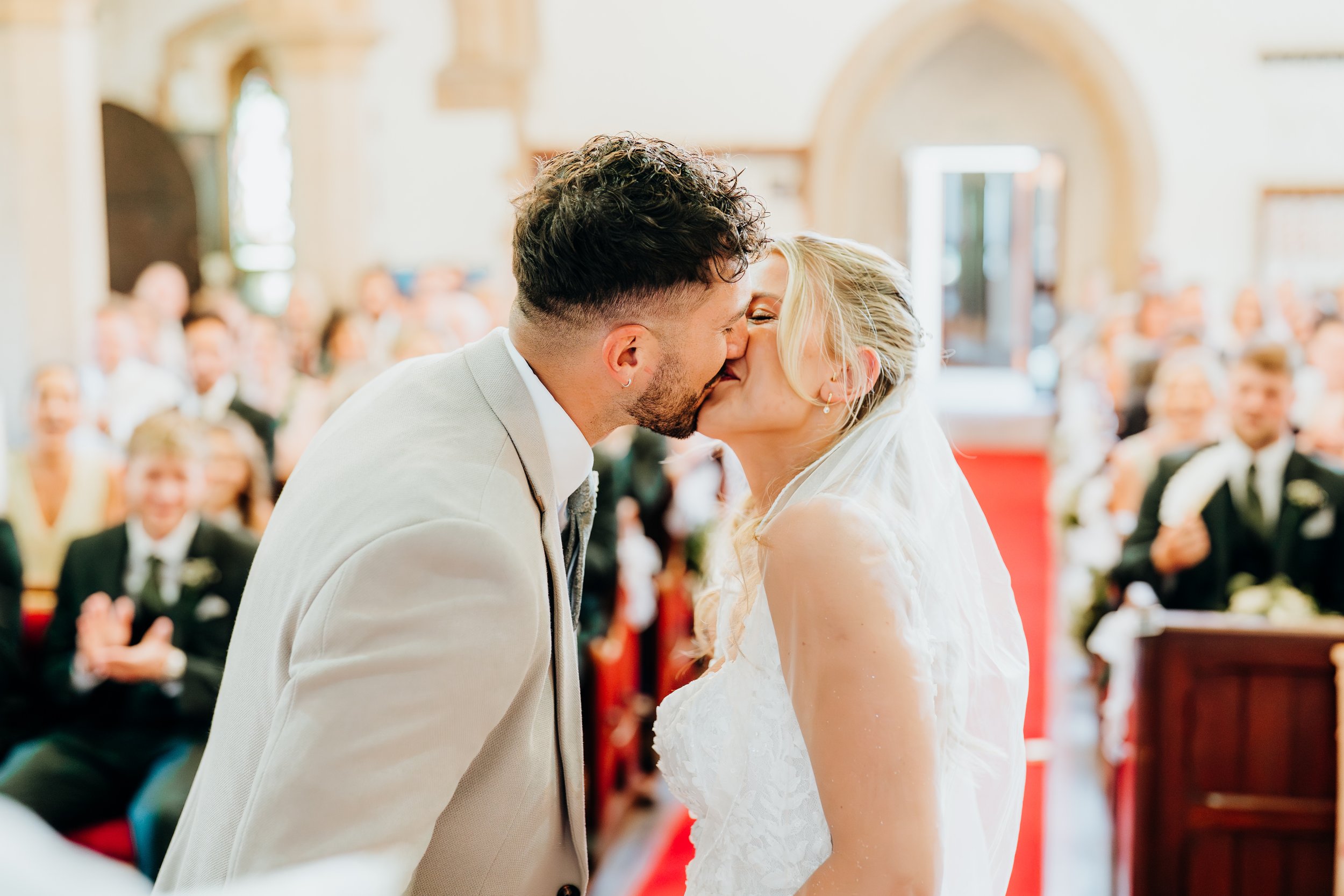Bride and groom's first kiss as a married couple during their wedding ceremony in Surrey