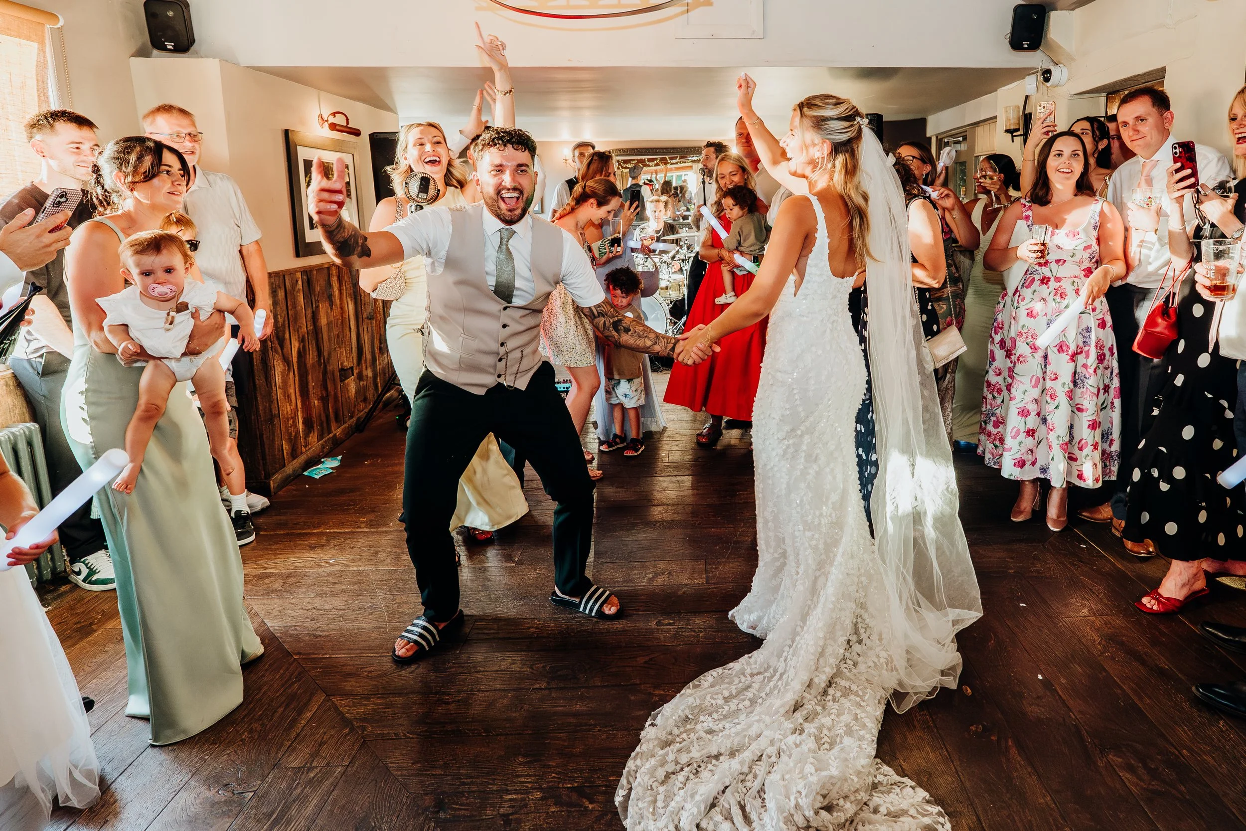 Bride and groom with family and baby on the dance floor at their wedding reception