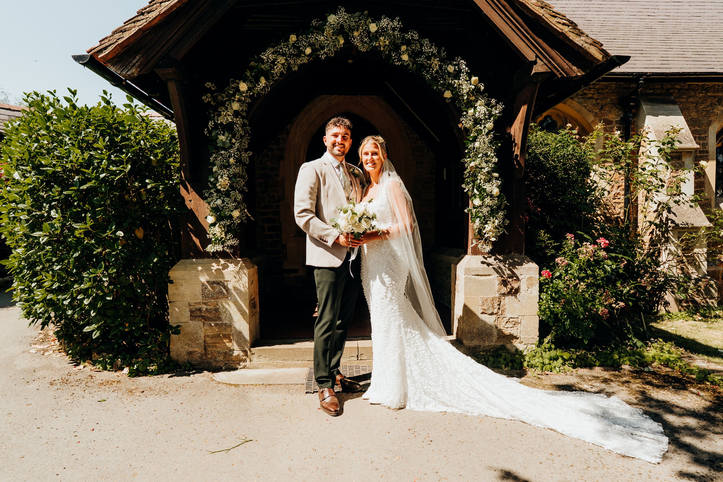 Bride and groom portrait at the stone gatehouse entrance of The Mill at Elstead wedding venue, Surrey