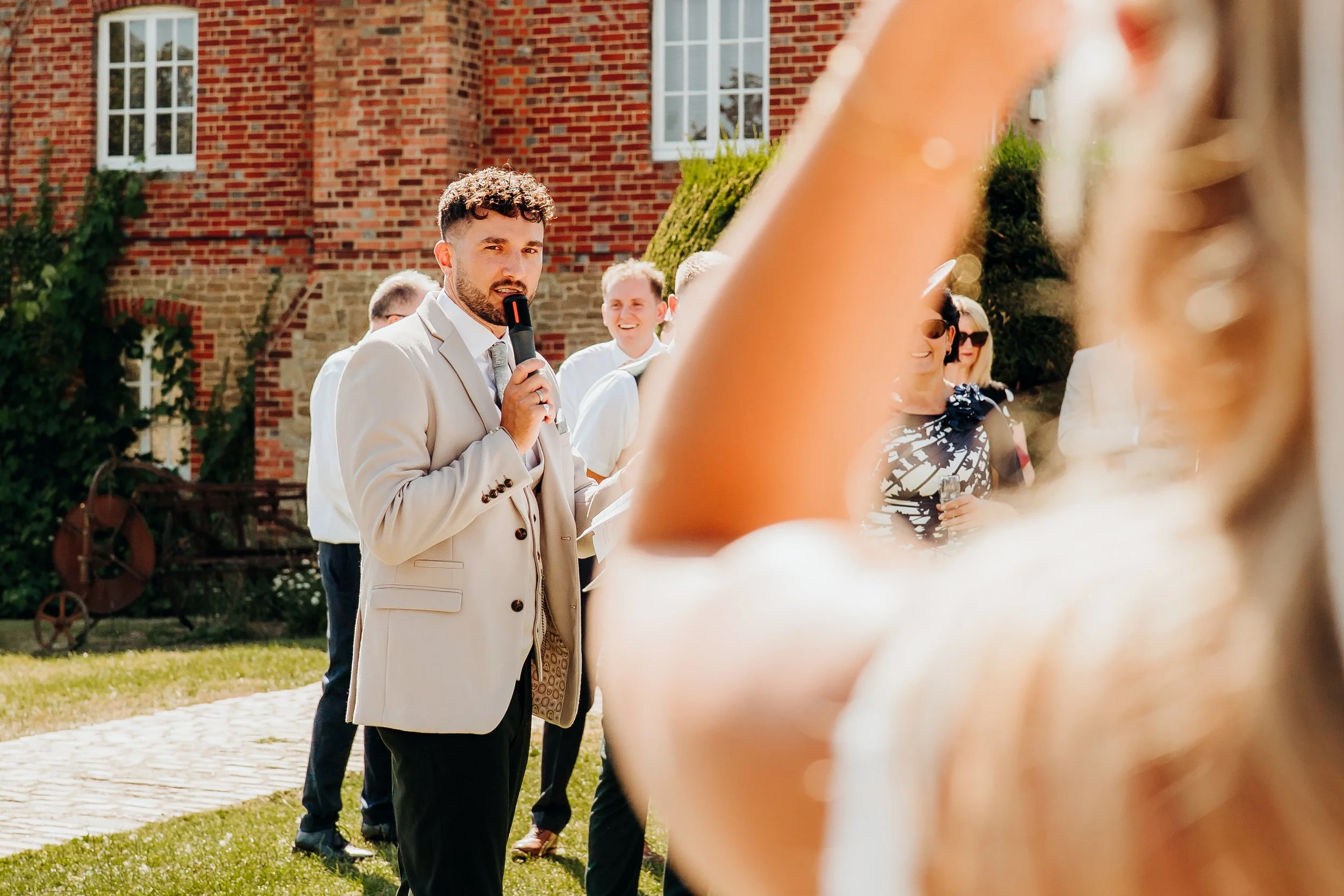 Best man giving speech outside The Mill at Elstead wedding venue, Surrey