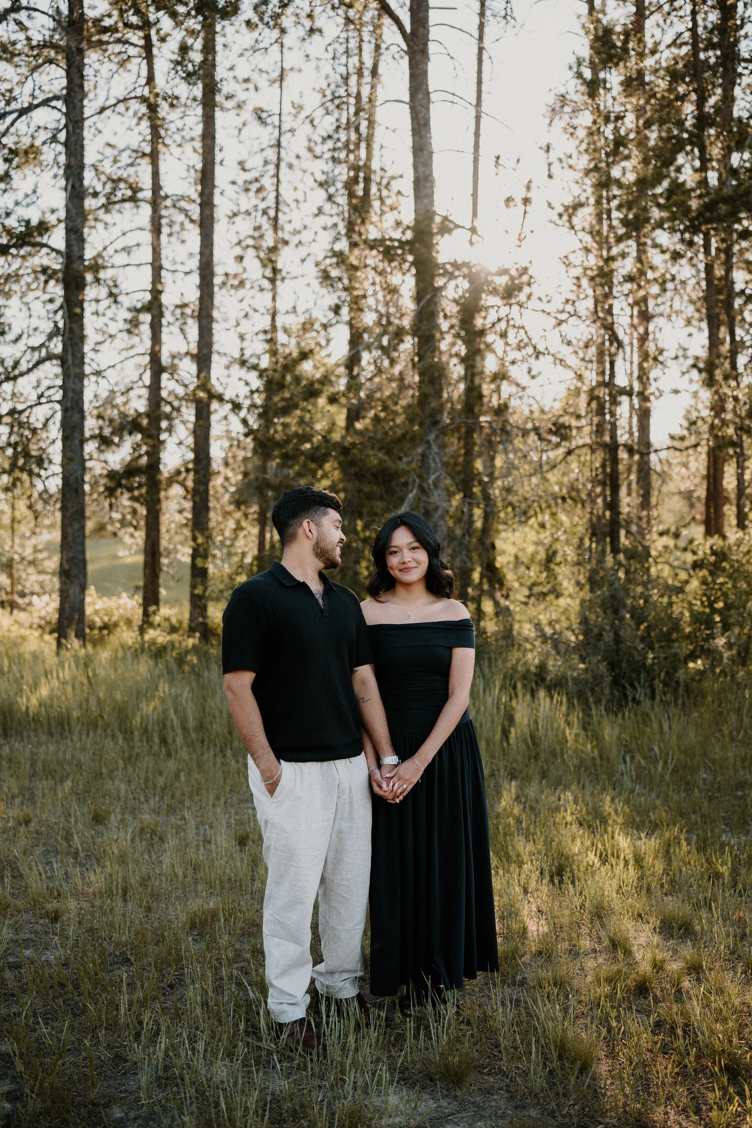 Engaged couple standing hand in hand at sunset in Glacier National Park