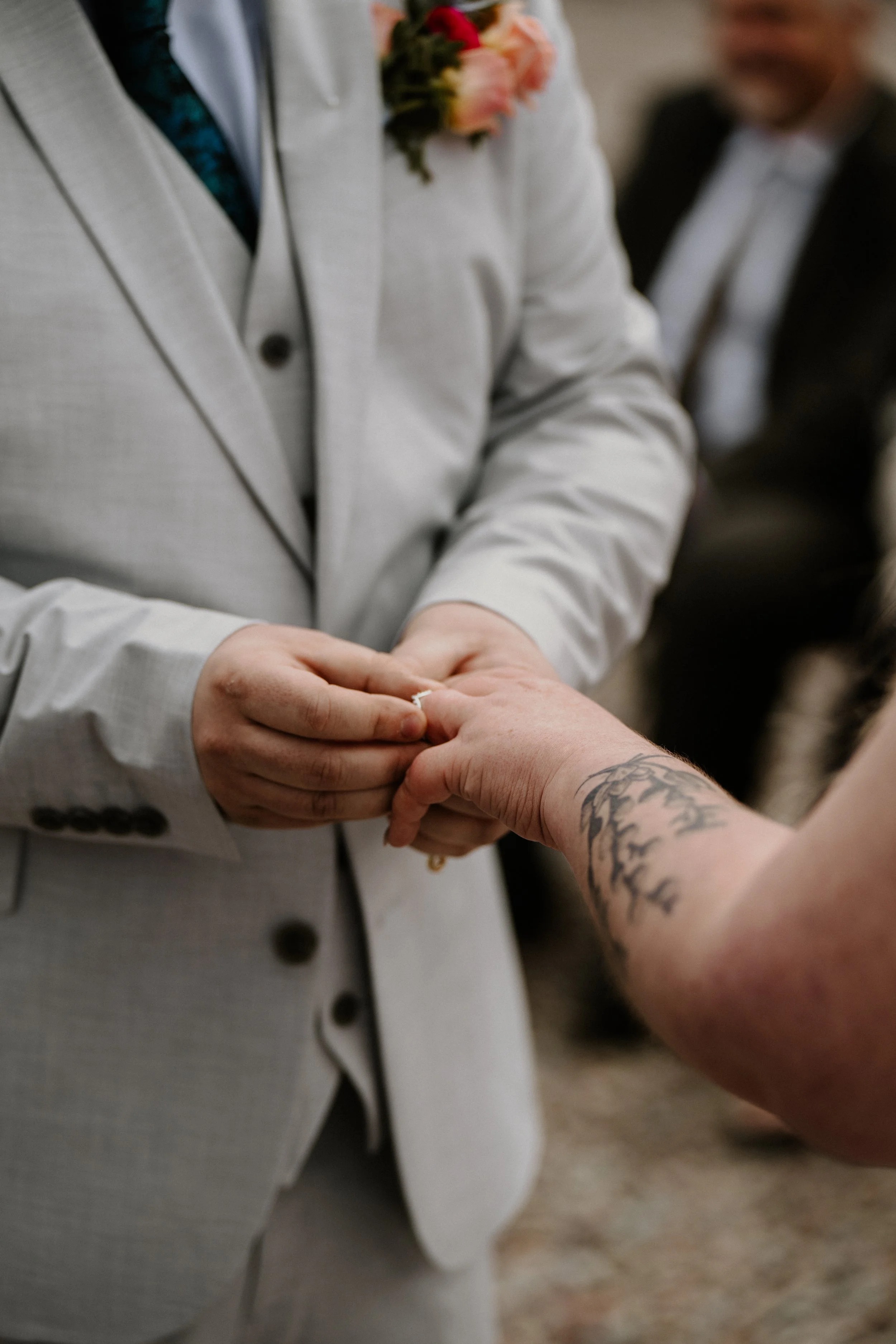 Close-up of the ring exchange during Alex and Lily's wedding ceremony.