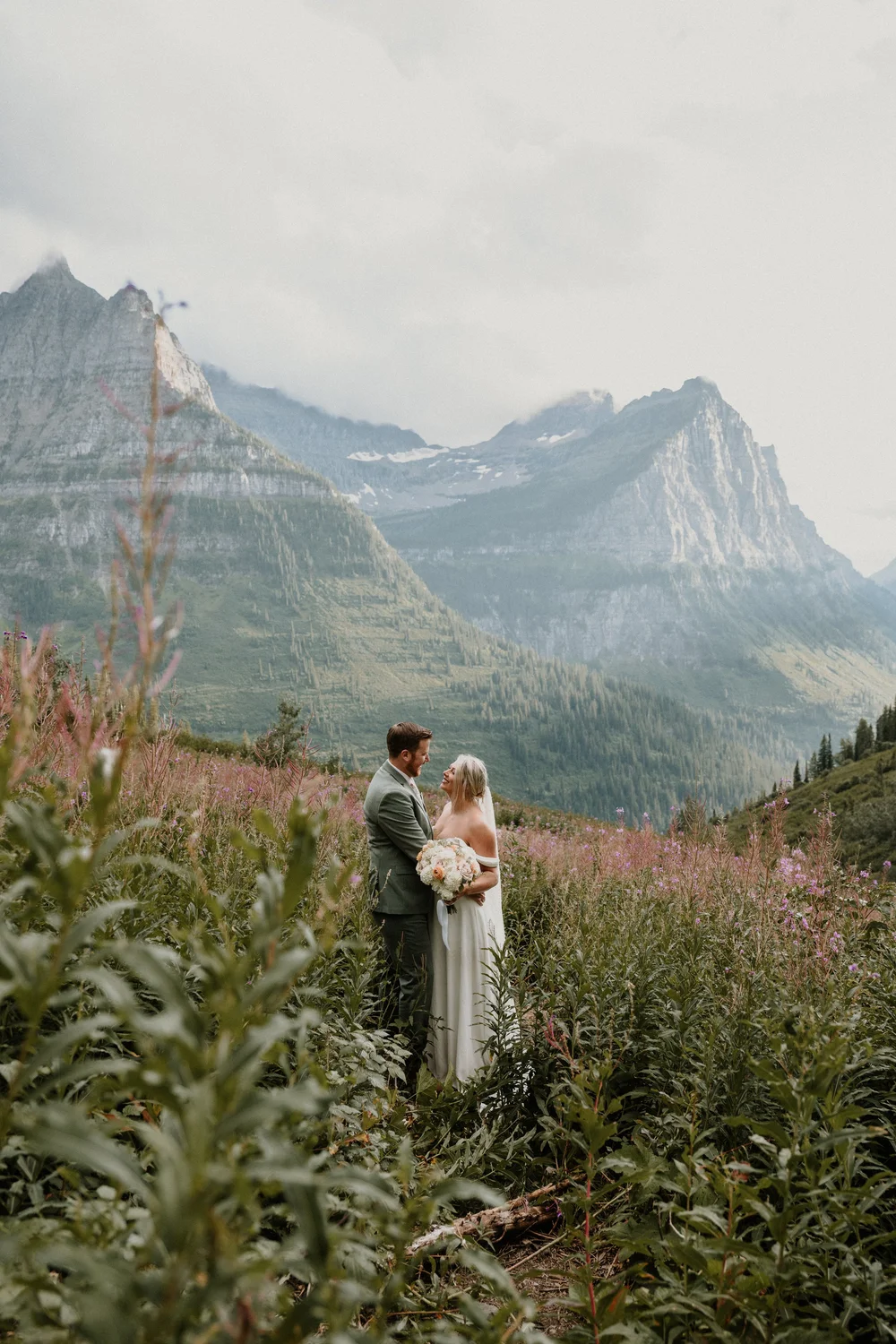 Couple in a mountain meadow full of wildflowers in Glacier National Park