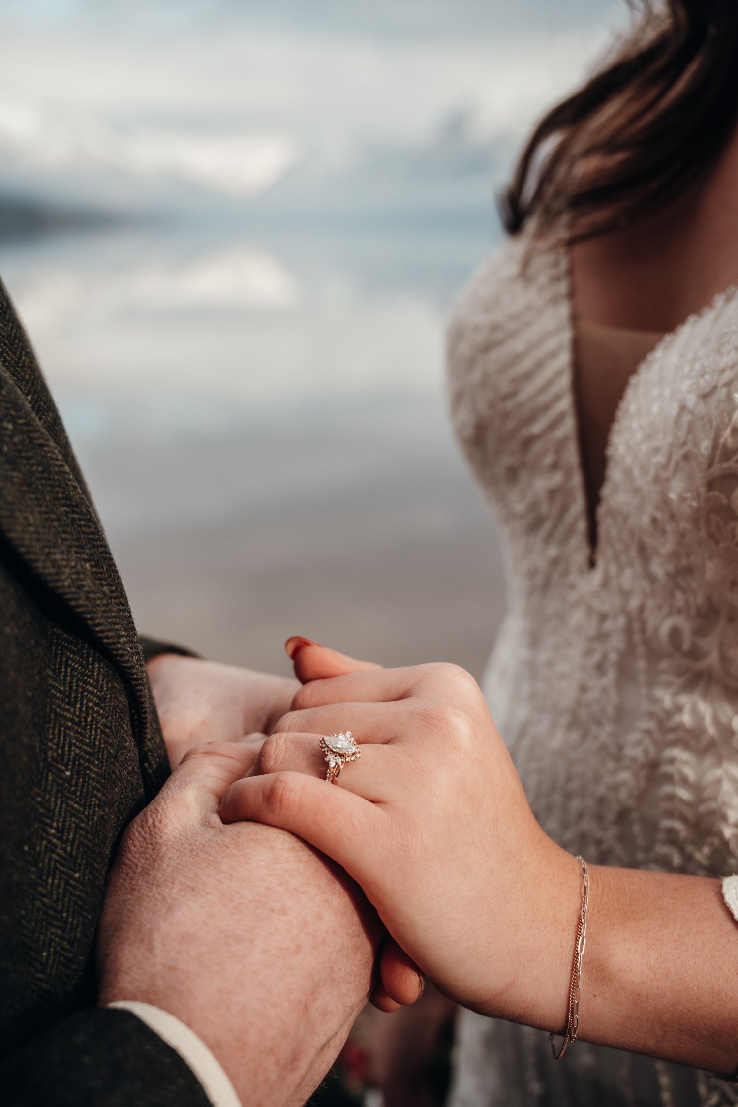 Close-up of the couple holding hands showing the engagement ring after their Glacier winter session