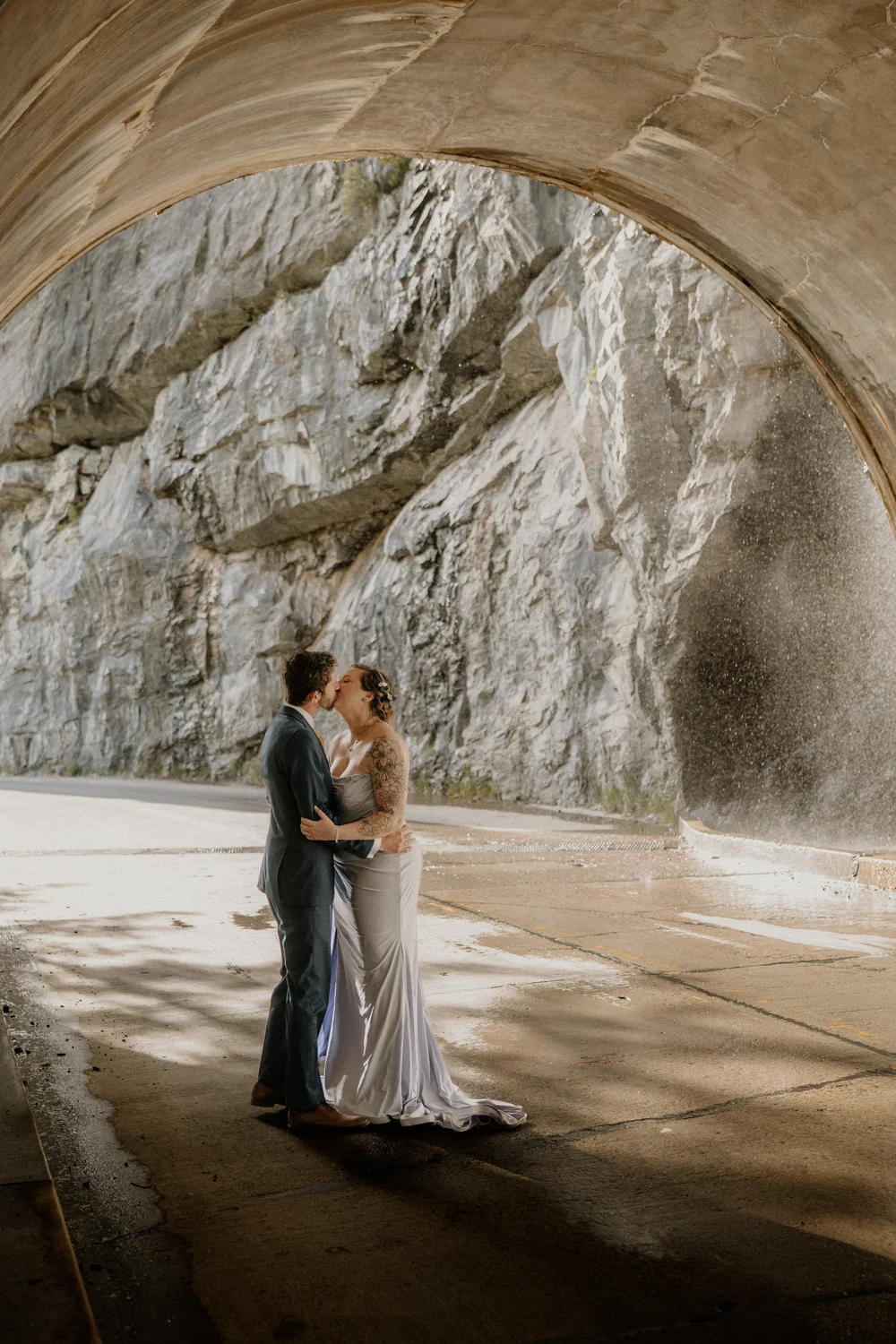 Couple kissing beneath a rock tunnel on Going-to-the-Sun Road