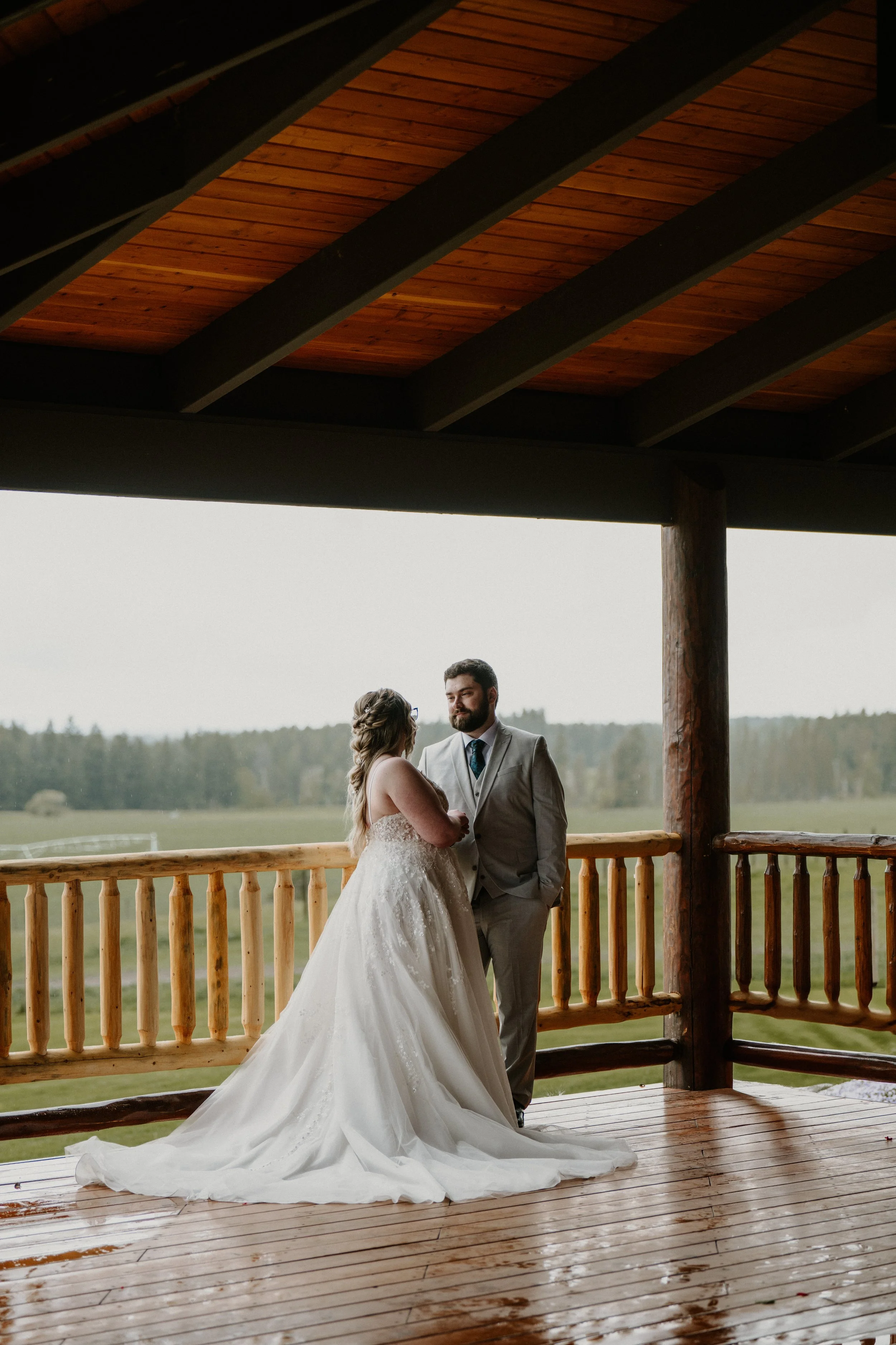 A quiet moment between the two on a wooden porch with countryside behind them.