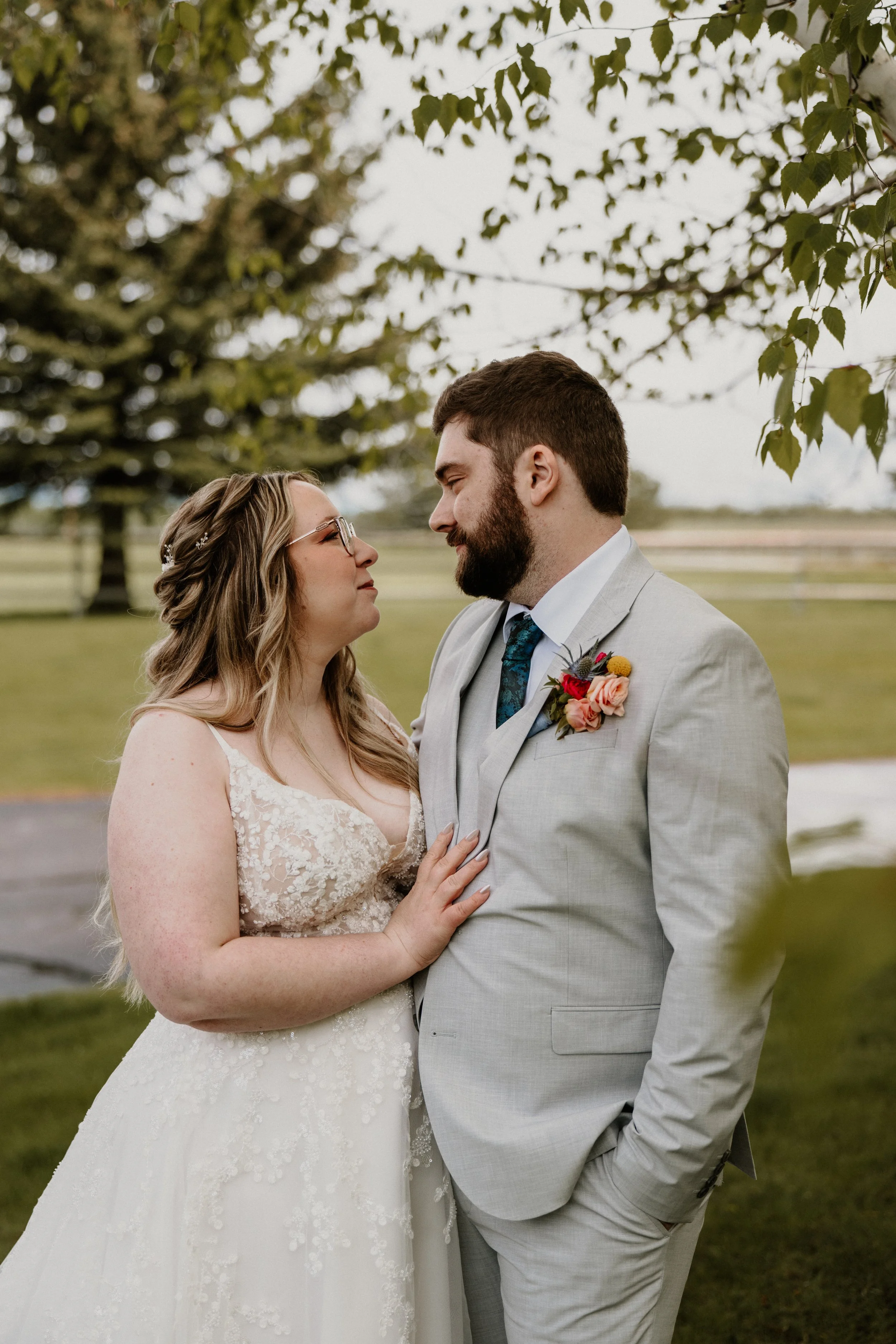Alex and Lily look at each other quietly outdoors with soft green light behind them.
