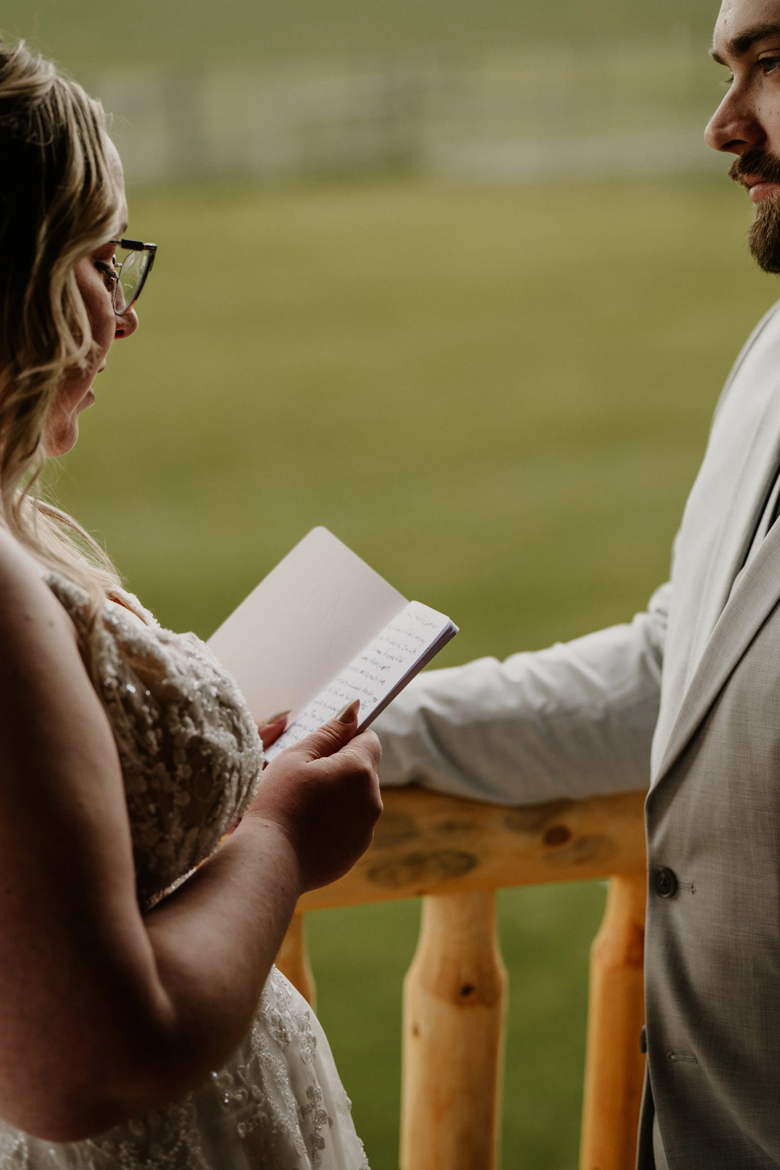 Lily reads her vows from a small notebook during the outdoor ceremony.