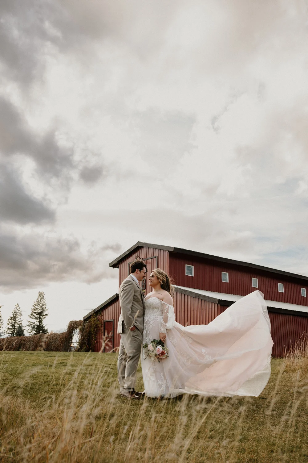 Couple in front of a red barn at a Flathead Valley wedding in Montana
