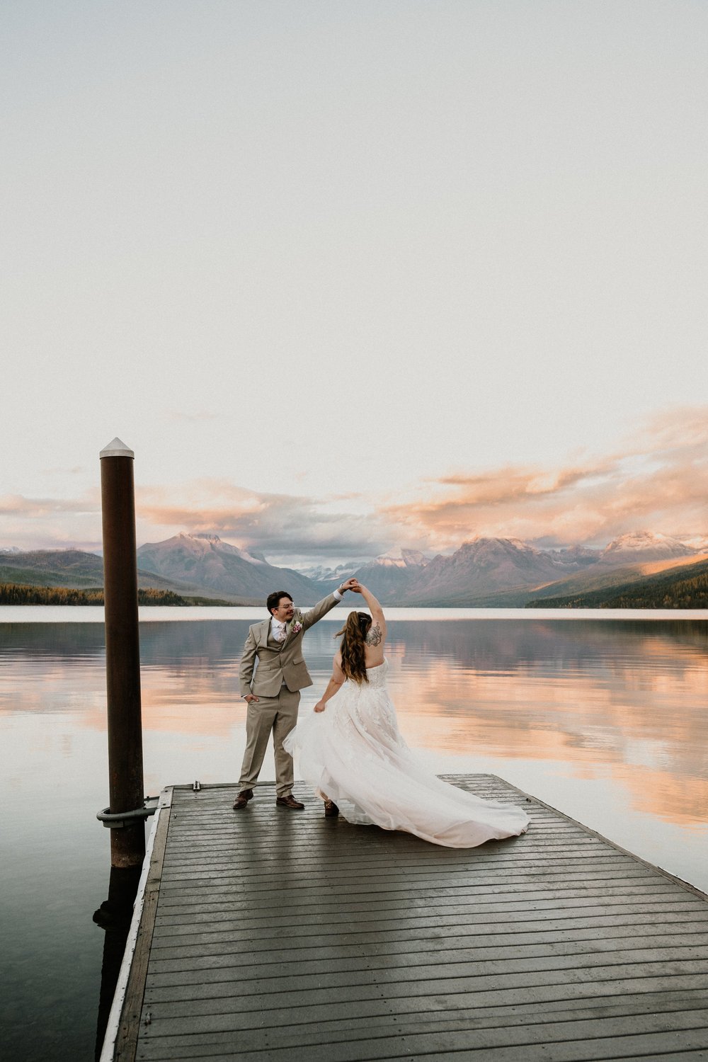Couple dancing on a dock at sunset at a Montana lake wedding