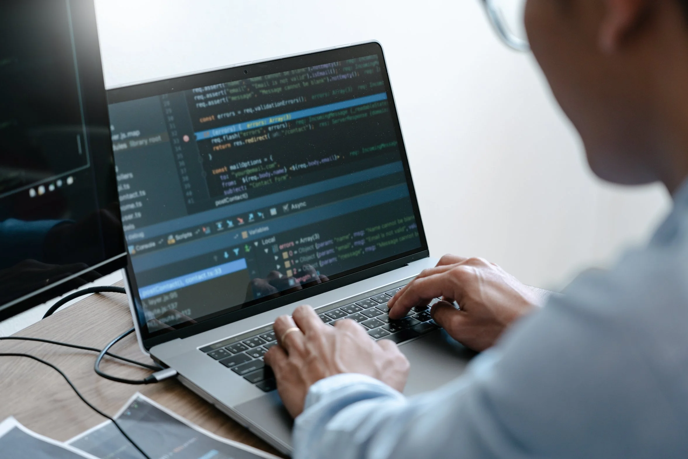 Close-up of hands typing code on a laptop