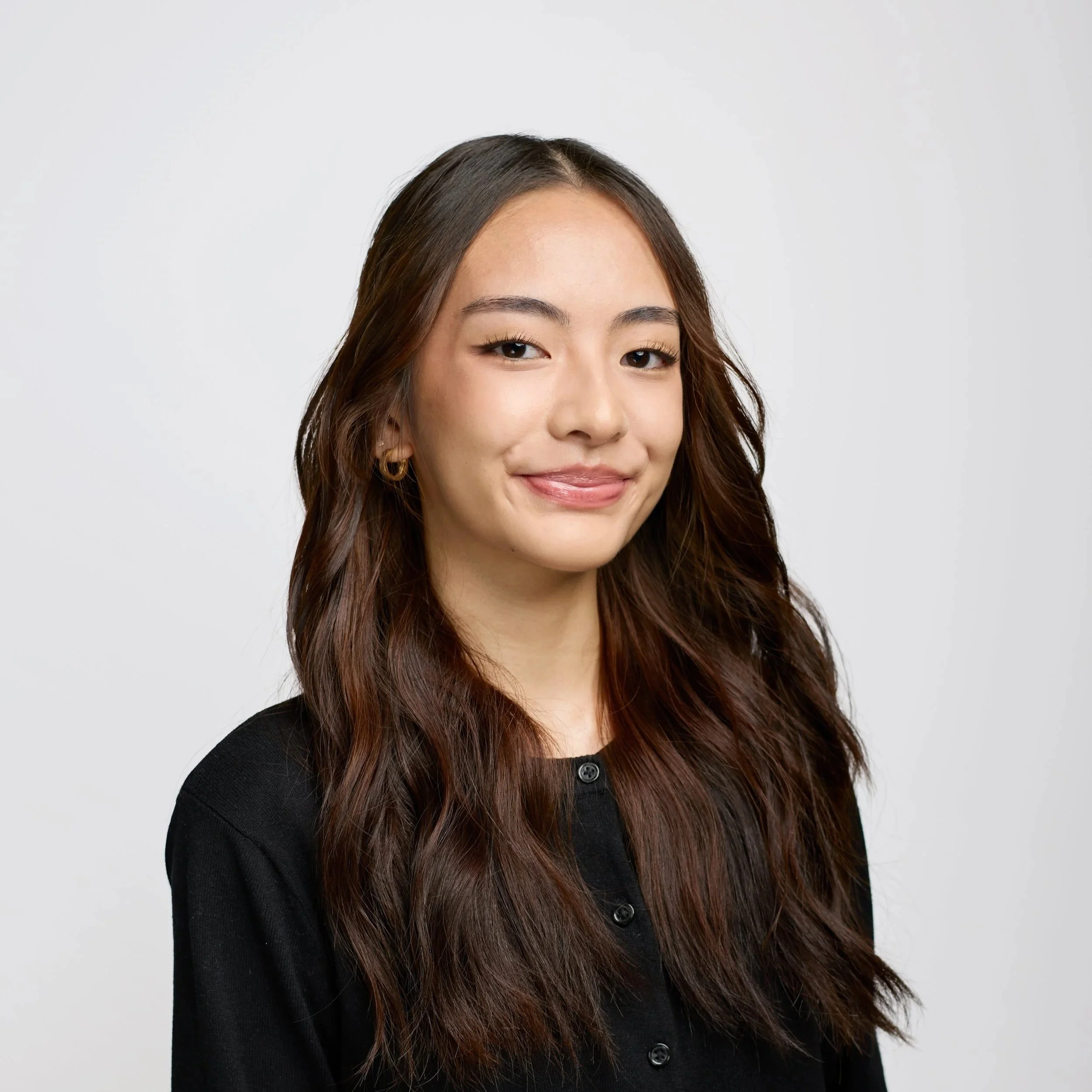 Headshot of a man with long hair, a thick gray beard, wearing glasses and a dark shirt, smiling against a black background.