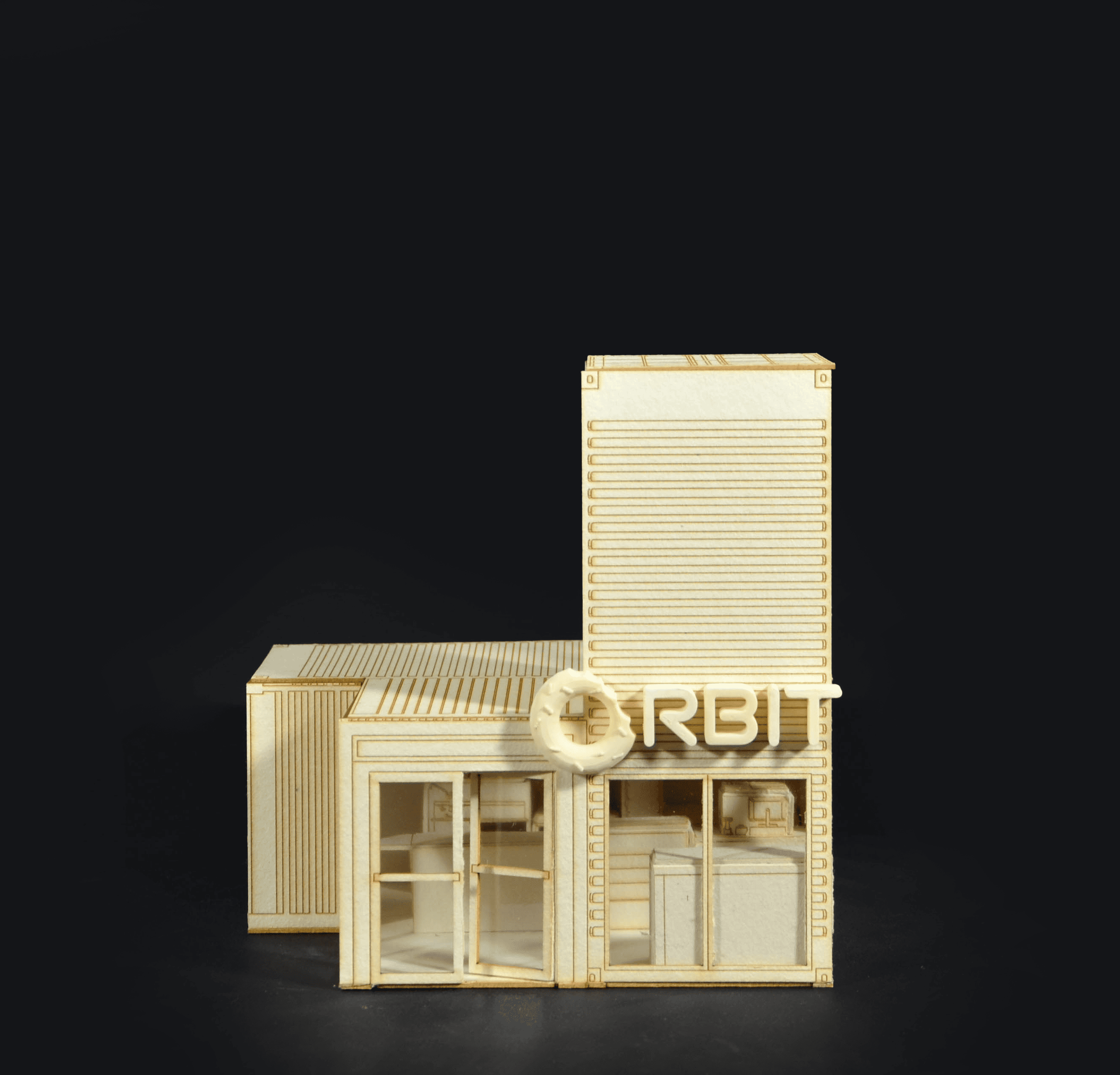 A miniature wooden architectural model of a building with multiple rooms and a rooftop terrace, set against a black background.