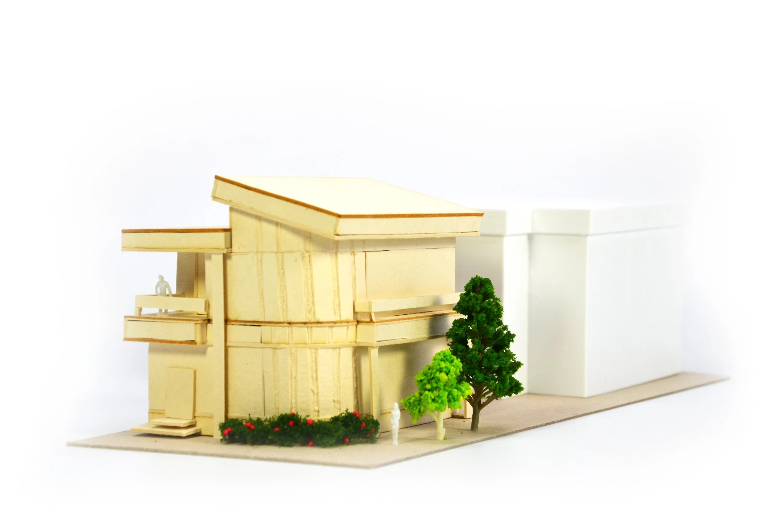 Architectural model of a modern multi-story building with trees and landscaping