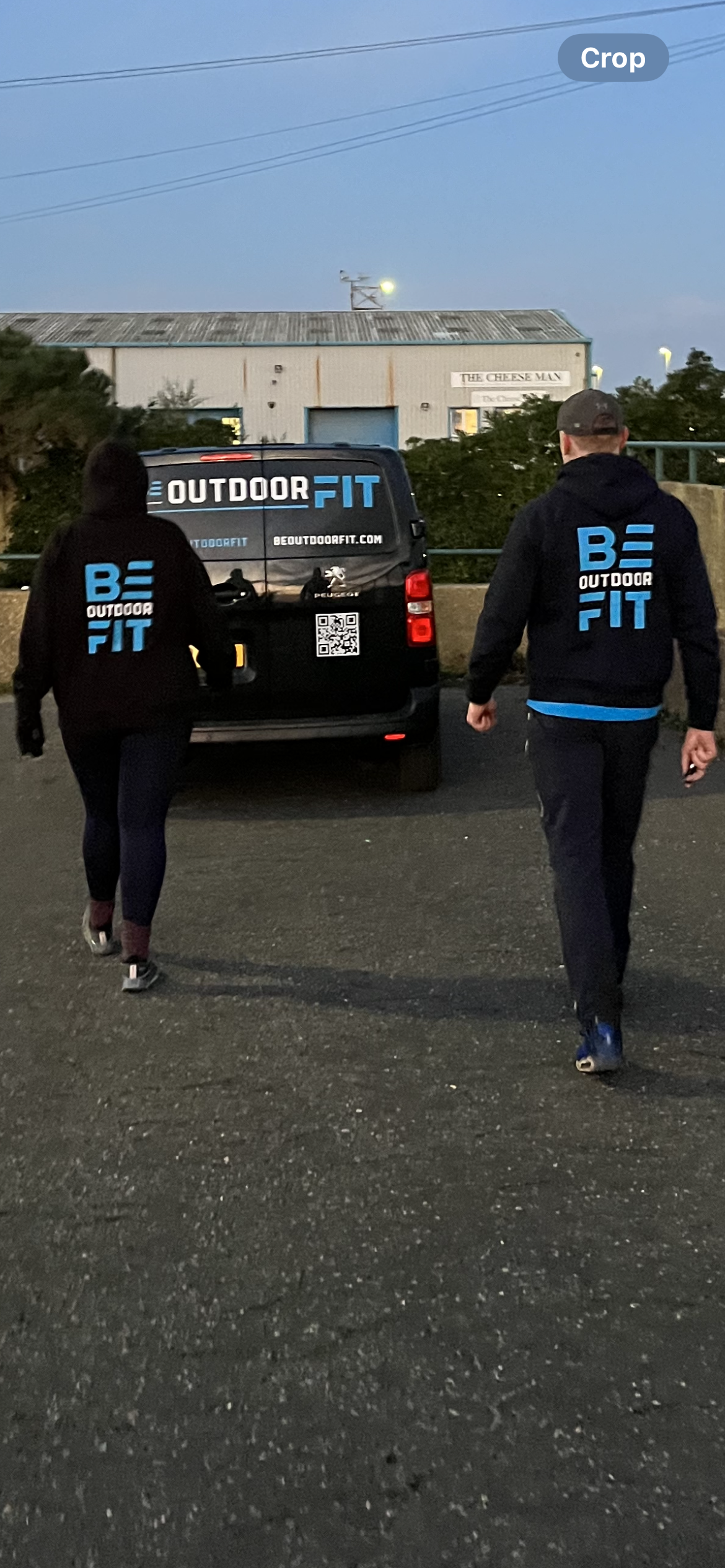 Two people wearing Beoutdoorfit hoodies walking along Hove seafront.