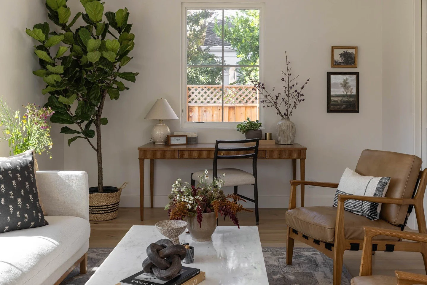 This living room is all about that sweet spot between cozy and collected. The soft, creamy sofa and warm leather chairs keep things neutral, but the textures give the room so much personality. The coffee table styling? It&rsquo;s a mix of sculptural 