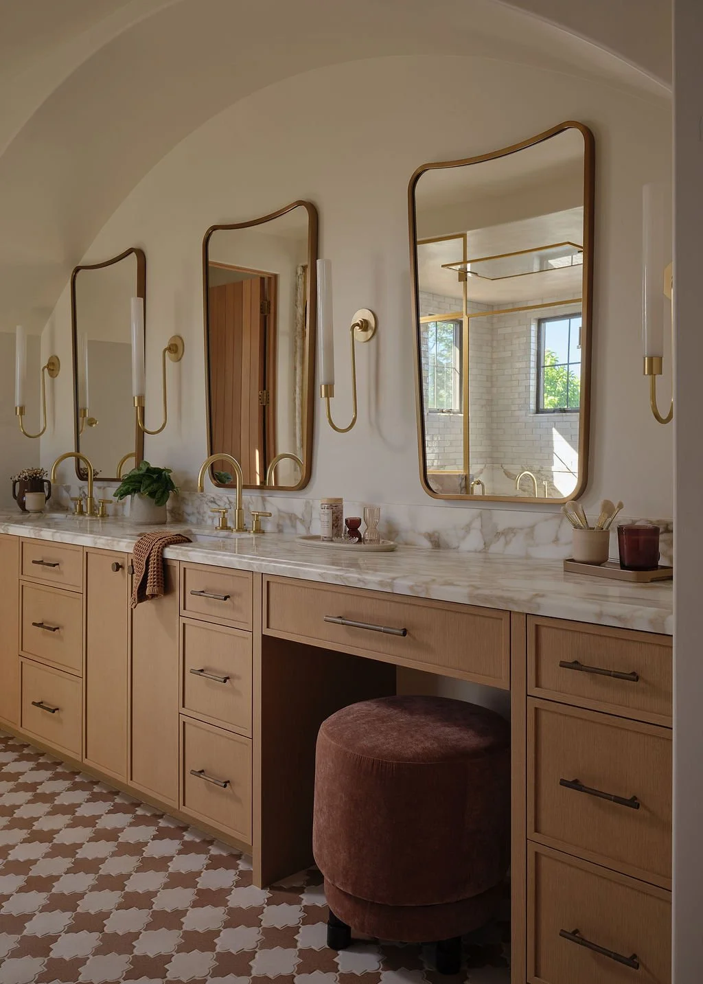 Mediterranean primary bathroom with custom wood vanity, marble countertop, brass sconces and arched mirrors