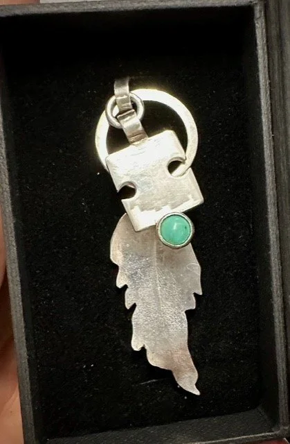 A pair of charms in silver with turquoise