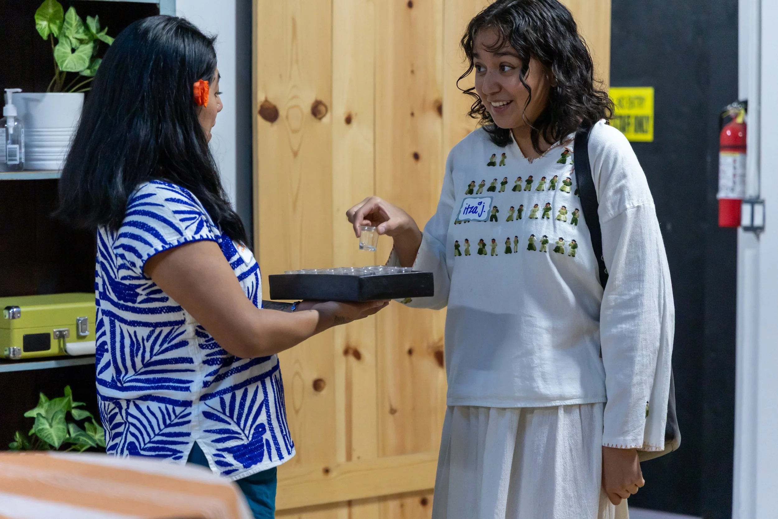 Gala-guetza guest being welcomed with mezcal from madrina. 