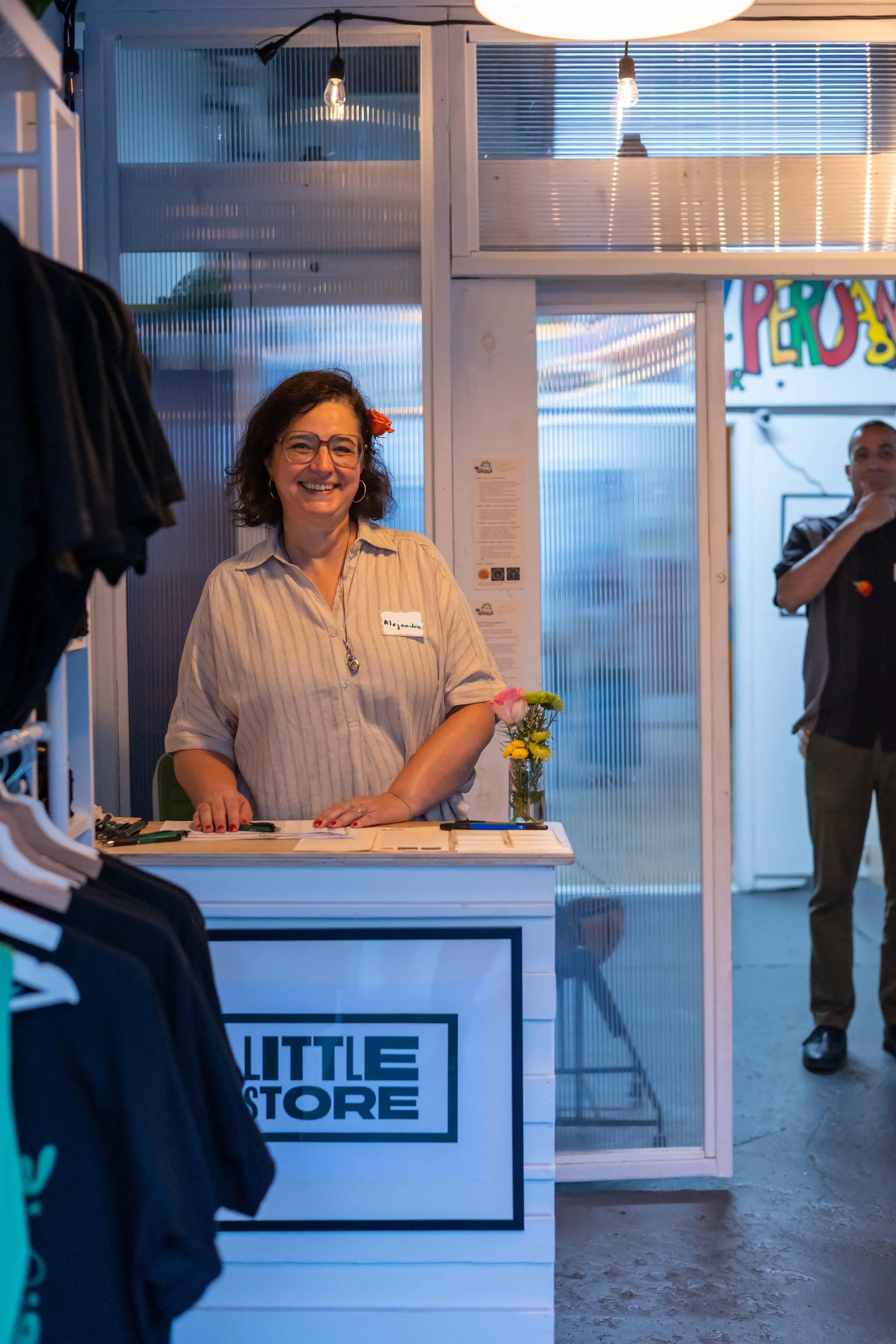 Portrait of Gala-guetza volunteer smiling by registration desk. 