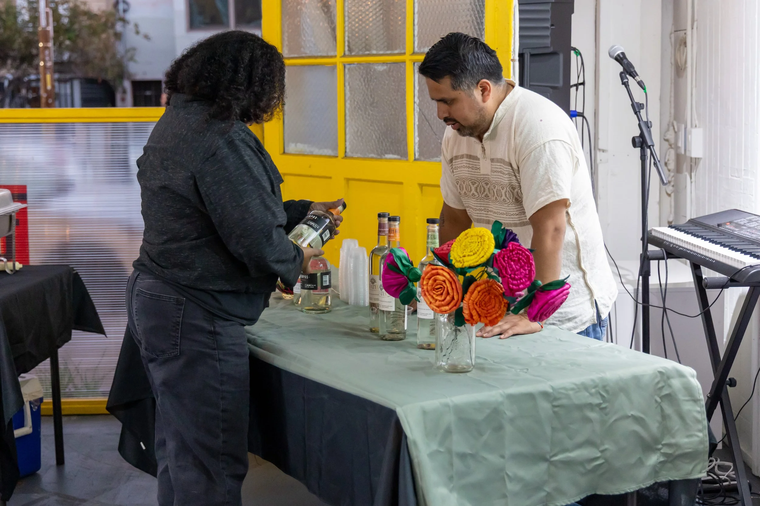 Gala-Guetza reading a bottle of Tres Tiempos mezcal. 