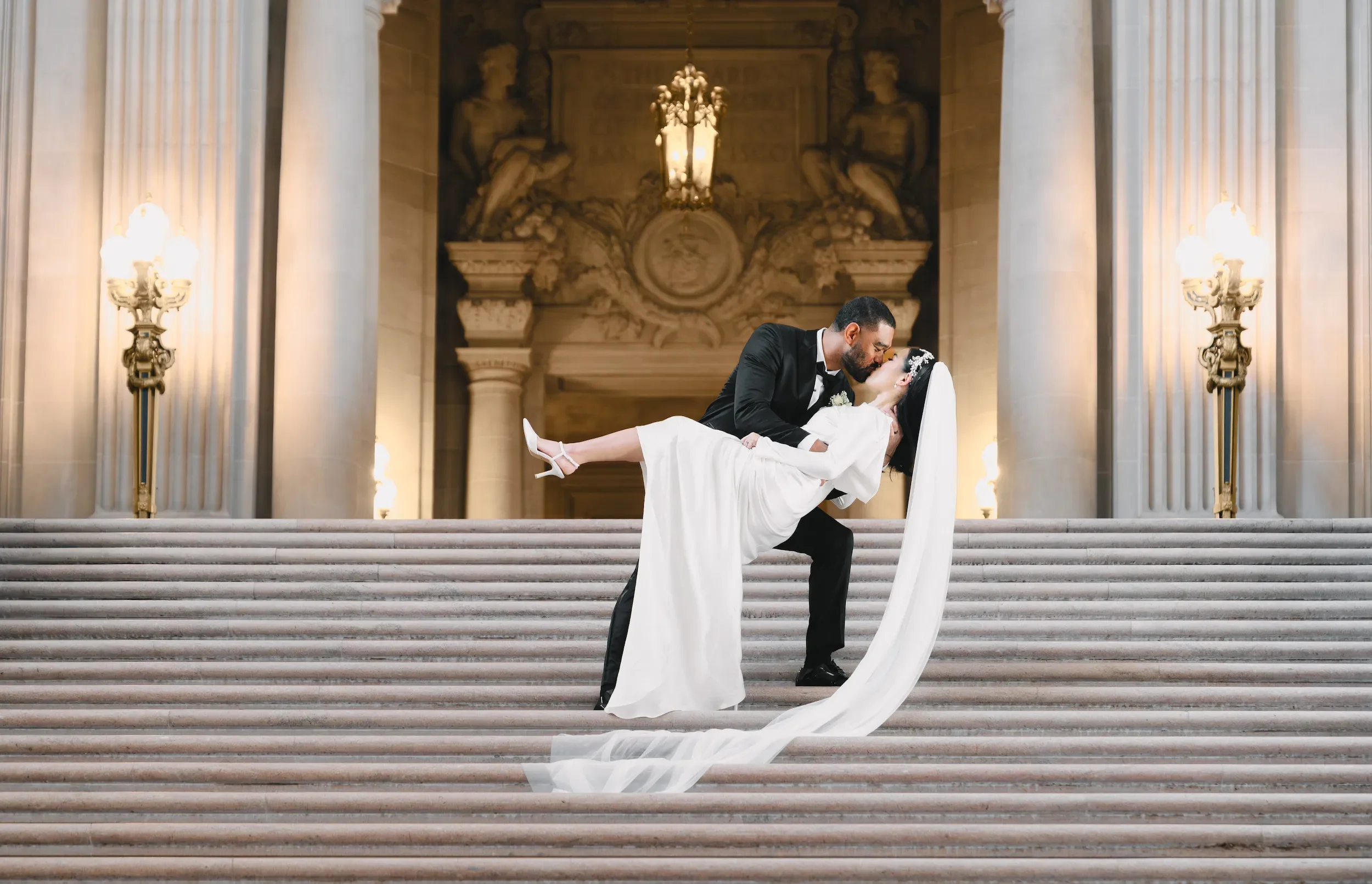 Luxury wedding photography in San Francisco, capturing a bride and groom on a grand staircase of a historic San Francisco City Hall, highlighting elegant architecture and timeless moments.