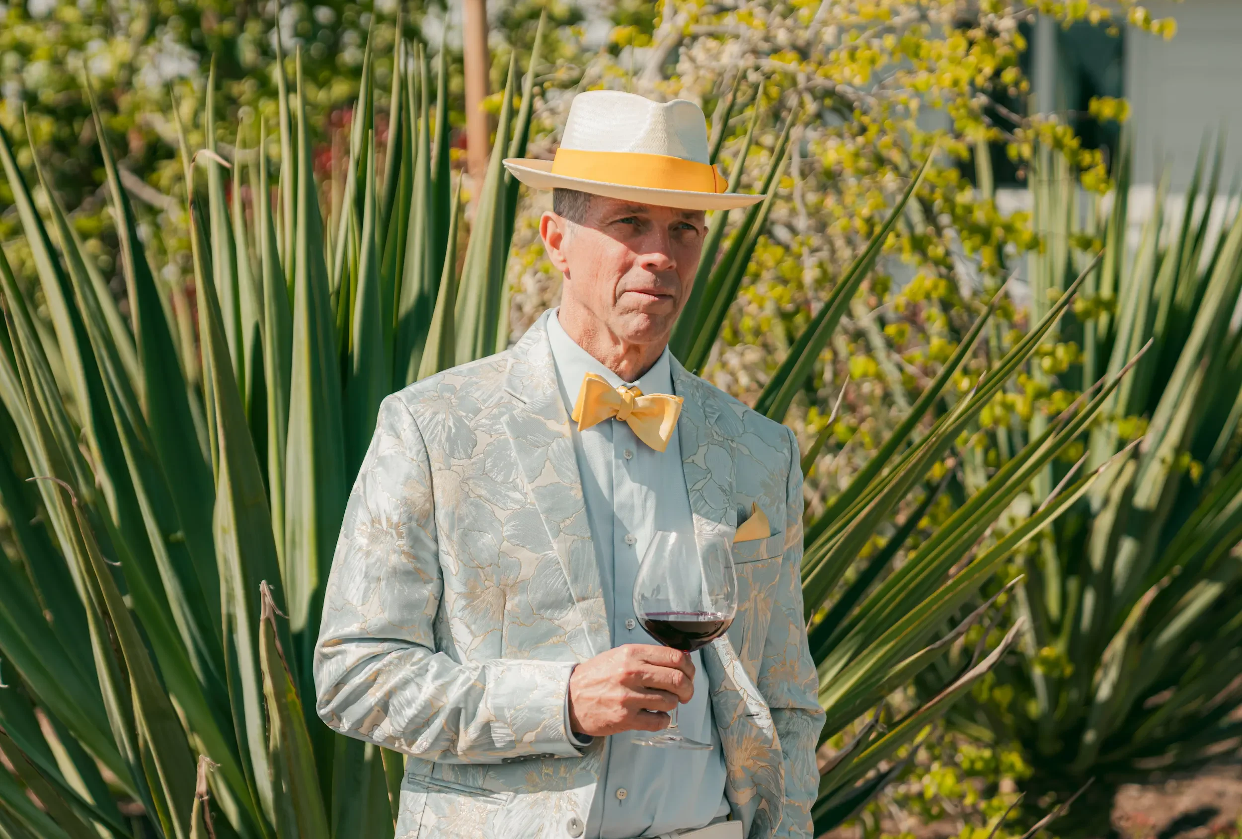 Outdoor event photography in San Francisco capturing a stylish garden party with guests enjoying wine, vibrant outfits, and a sunny celebration atmosphere.